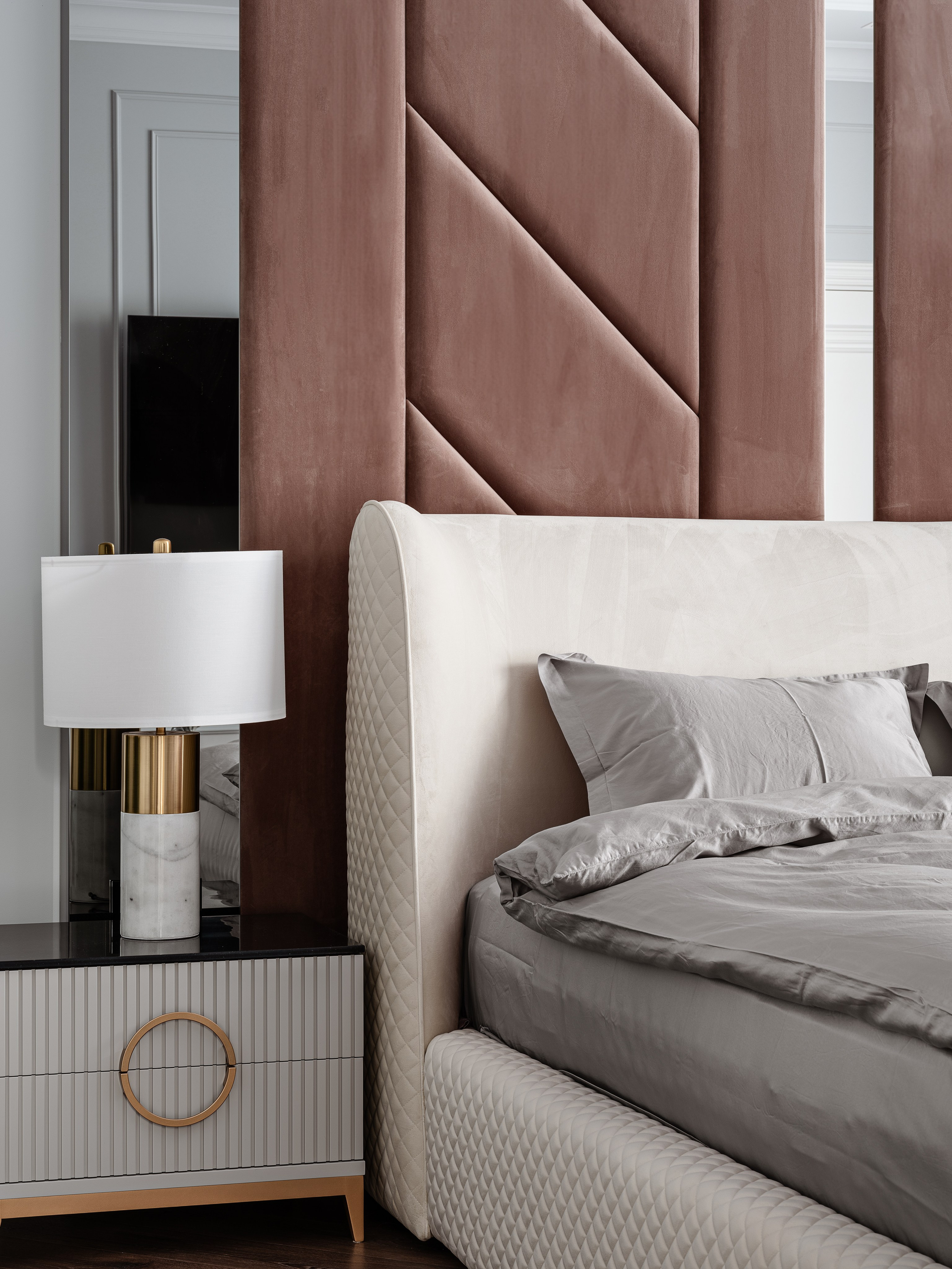 Стильное изголовье кровати с мягкой отделкой и прикроватная тумба с лампой в современном интерьере спальни, текстиль в спокойных оттенках, дизайн Евгении Ермошиной, фотосъёмка интерьера Сергеем Денисенко.