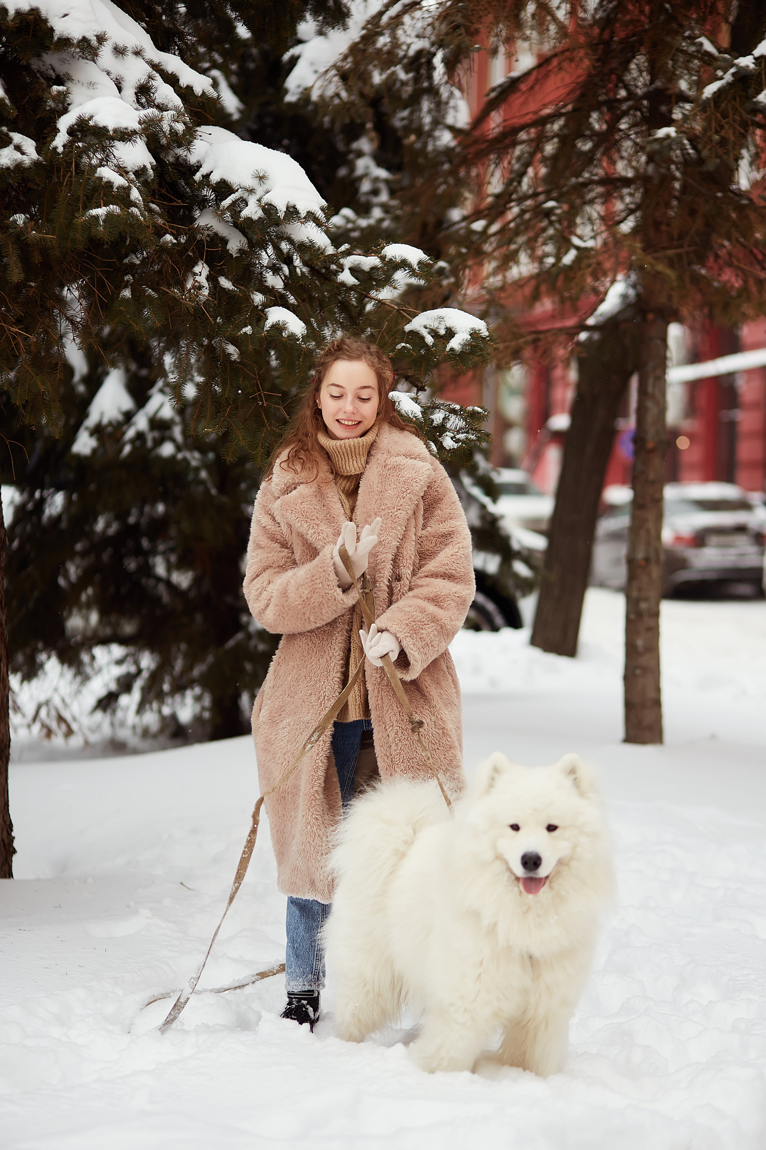 Девушка на зимней прогулке в Новый Год со своей собакой около Елки