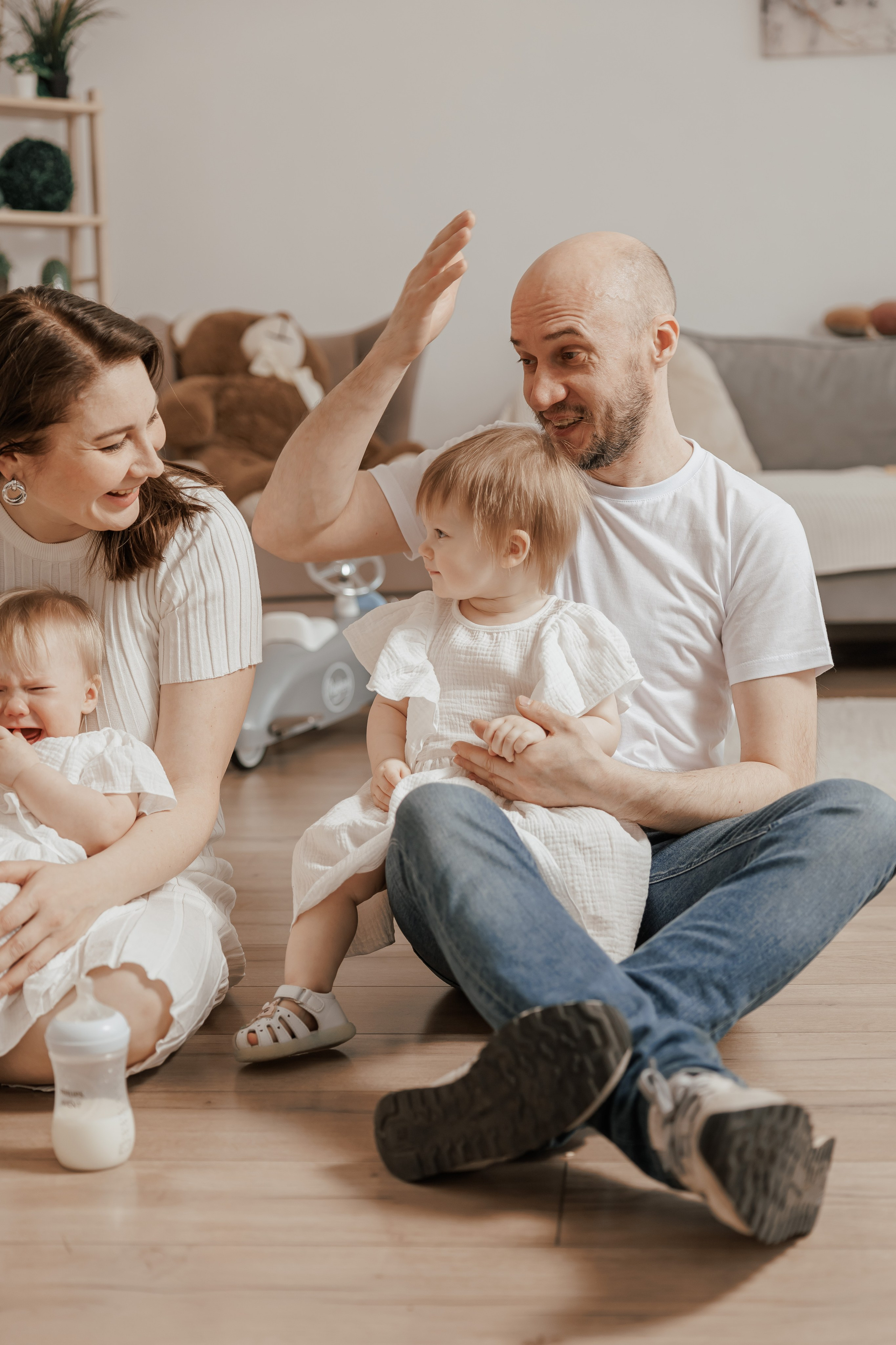 Семейная фотосессия для семьи с девочками близнецами на годик одежда в светлых тонах светлая бежевая студия в Москве теплые тона