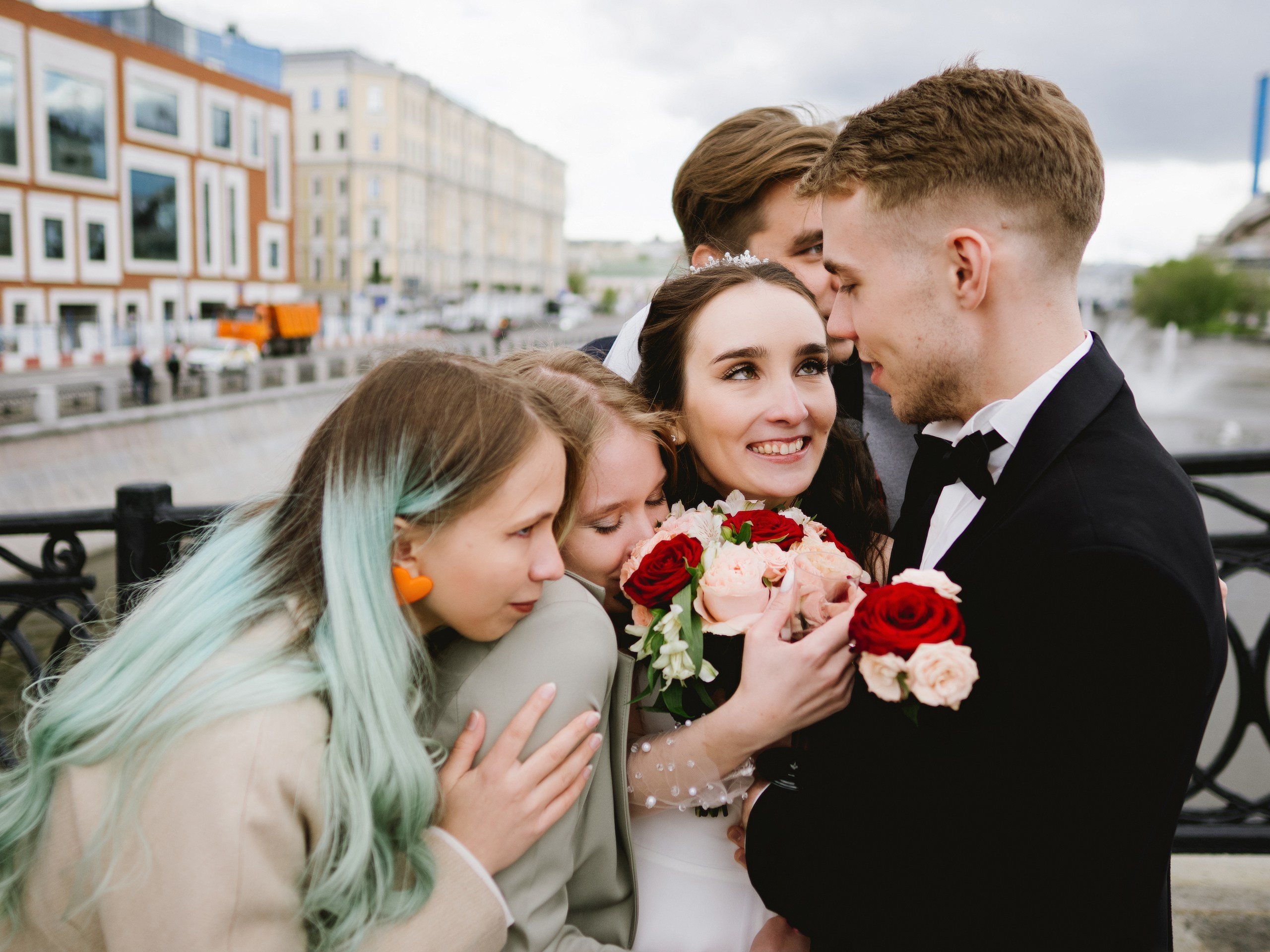 На фото молодожёны обнимаются с друзьями на своей свадьбе в Москве