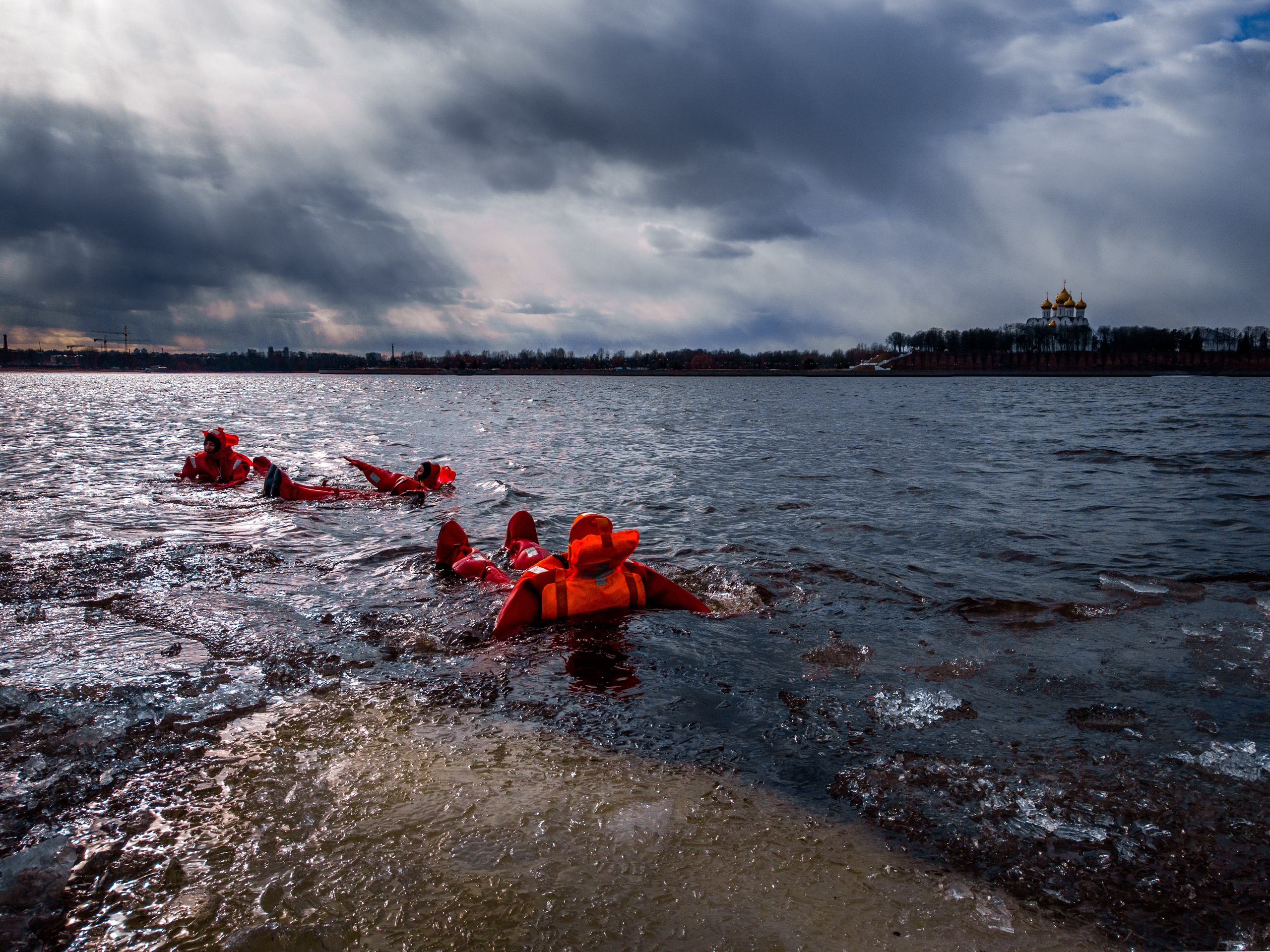 Люди купаются среди льдин, в спасательных оранжевых термо костюмах, айс флоатинг Ярославль