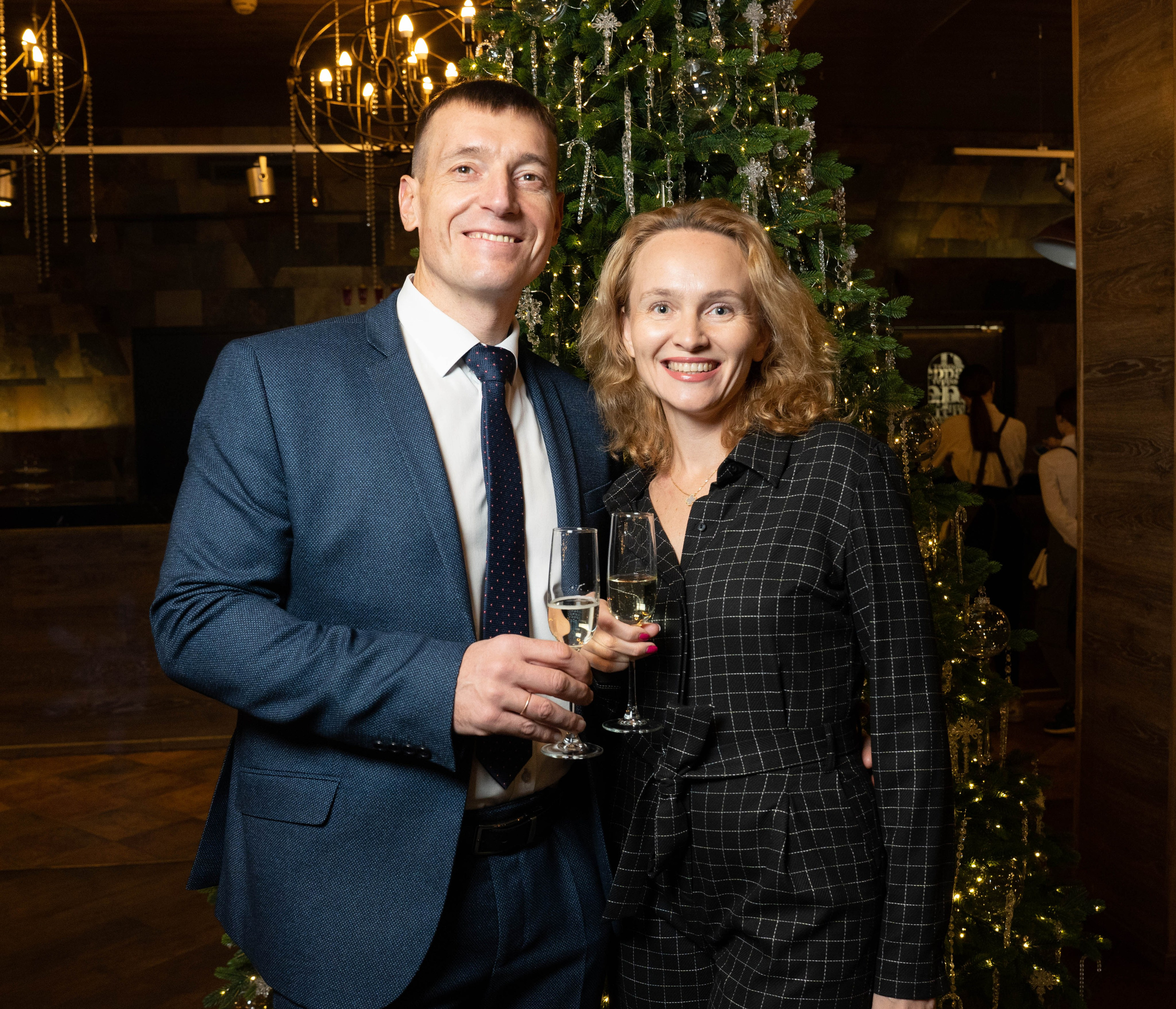 пара на корпоративе у новогодней наряженной елки