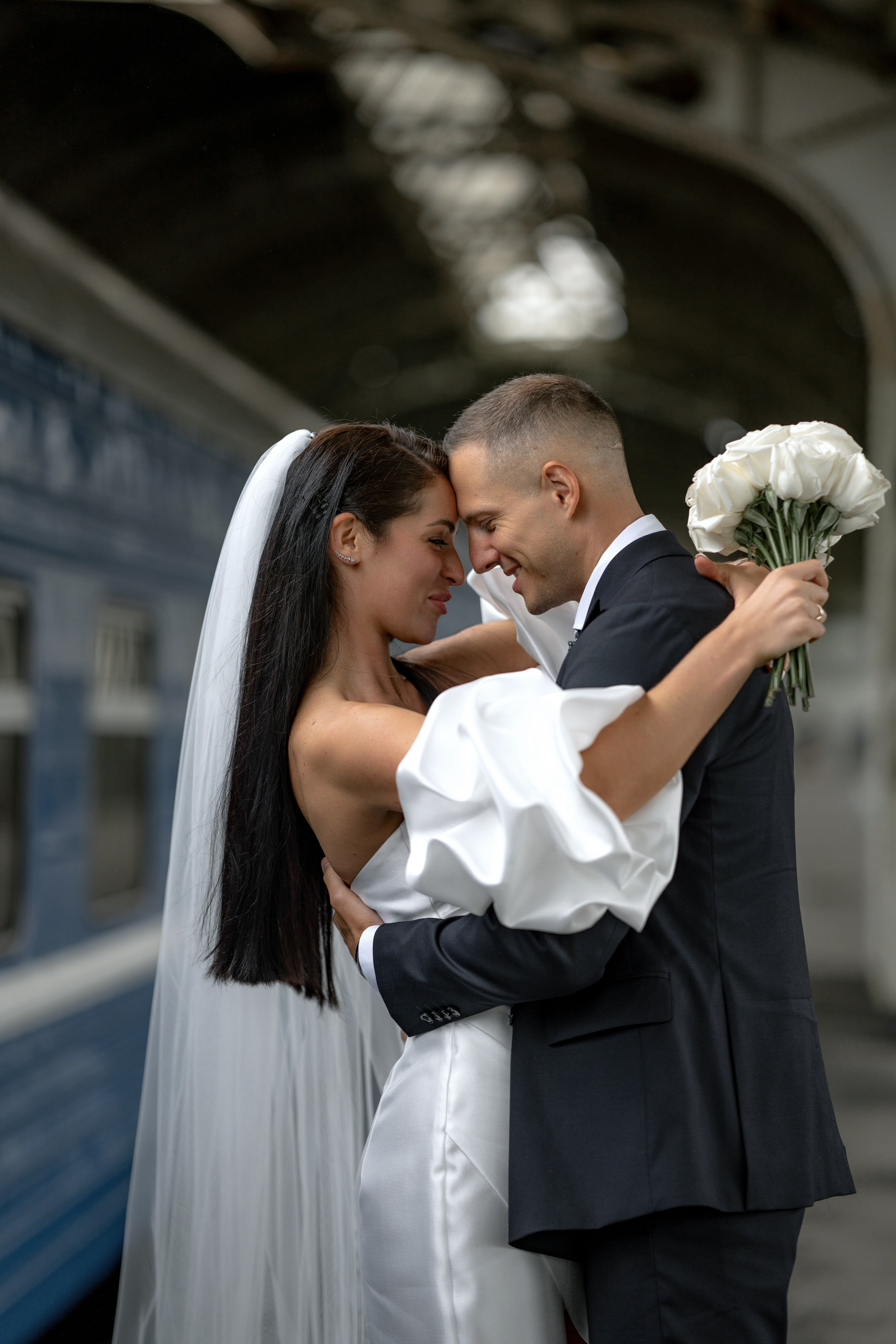 жених и невеста красиво целуются на перроне Витебского вокзала в Санкт-Петербурге
