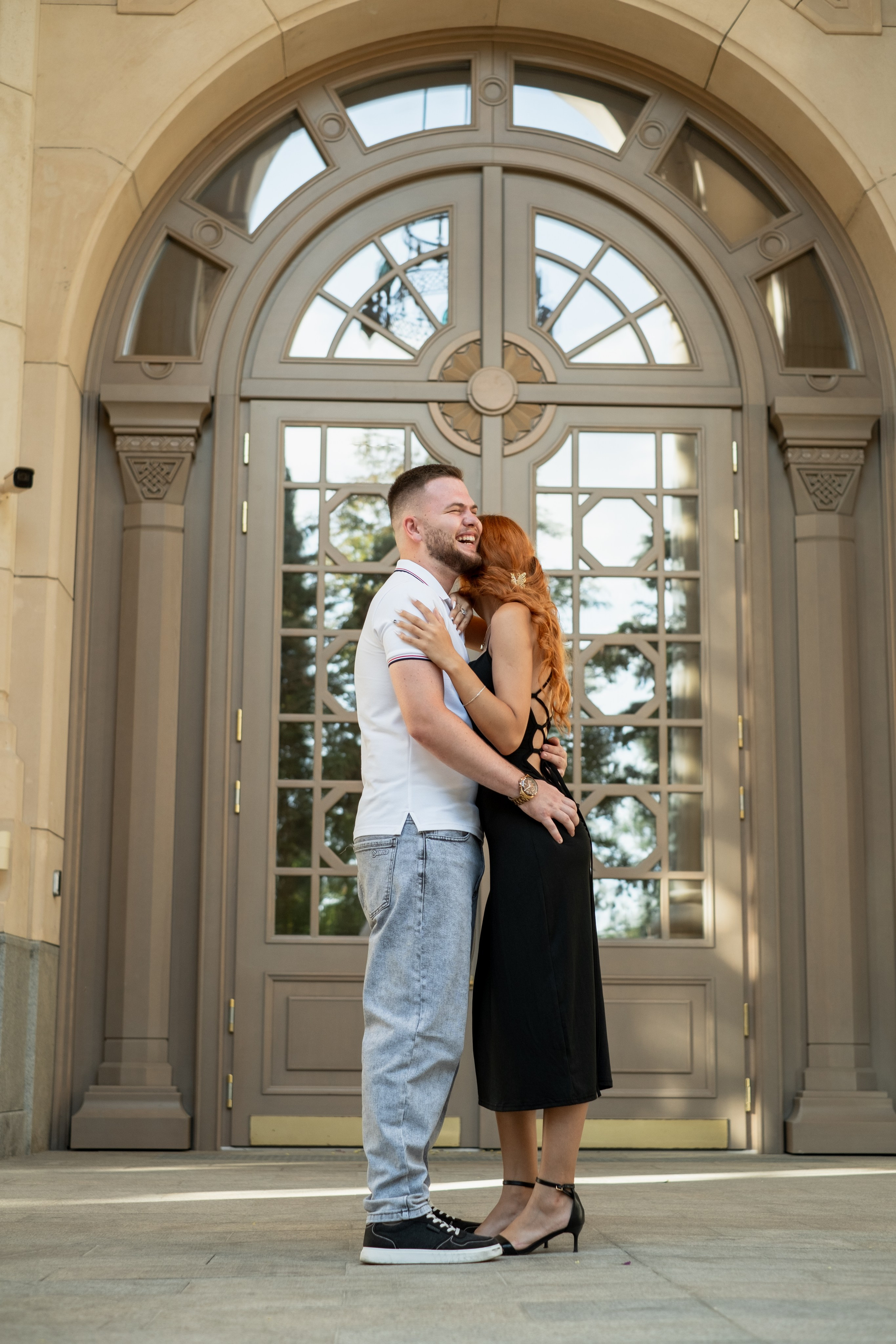 Девушка и парень обнимаются и смеются на фоне красивой двери в новом херсонесе