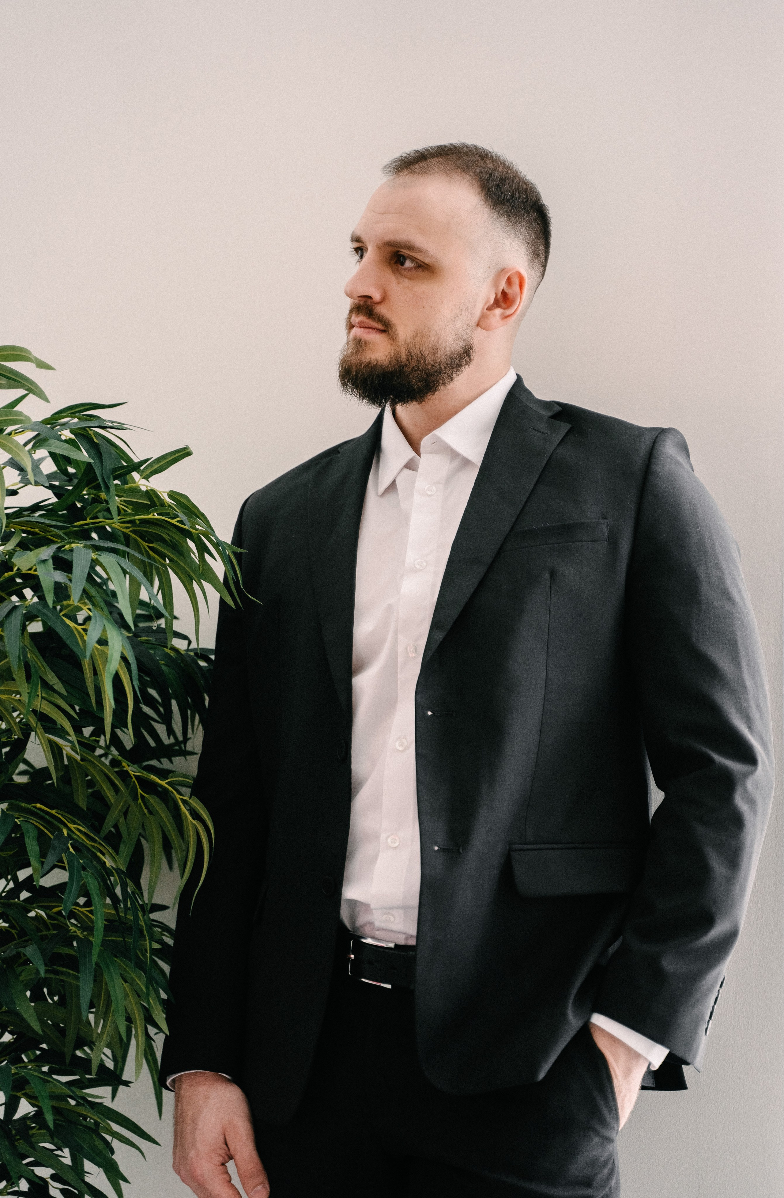 жених в чёрном костюме позирует в студии