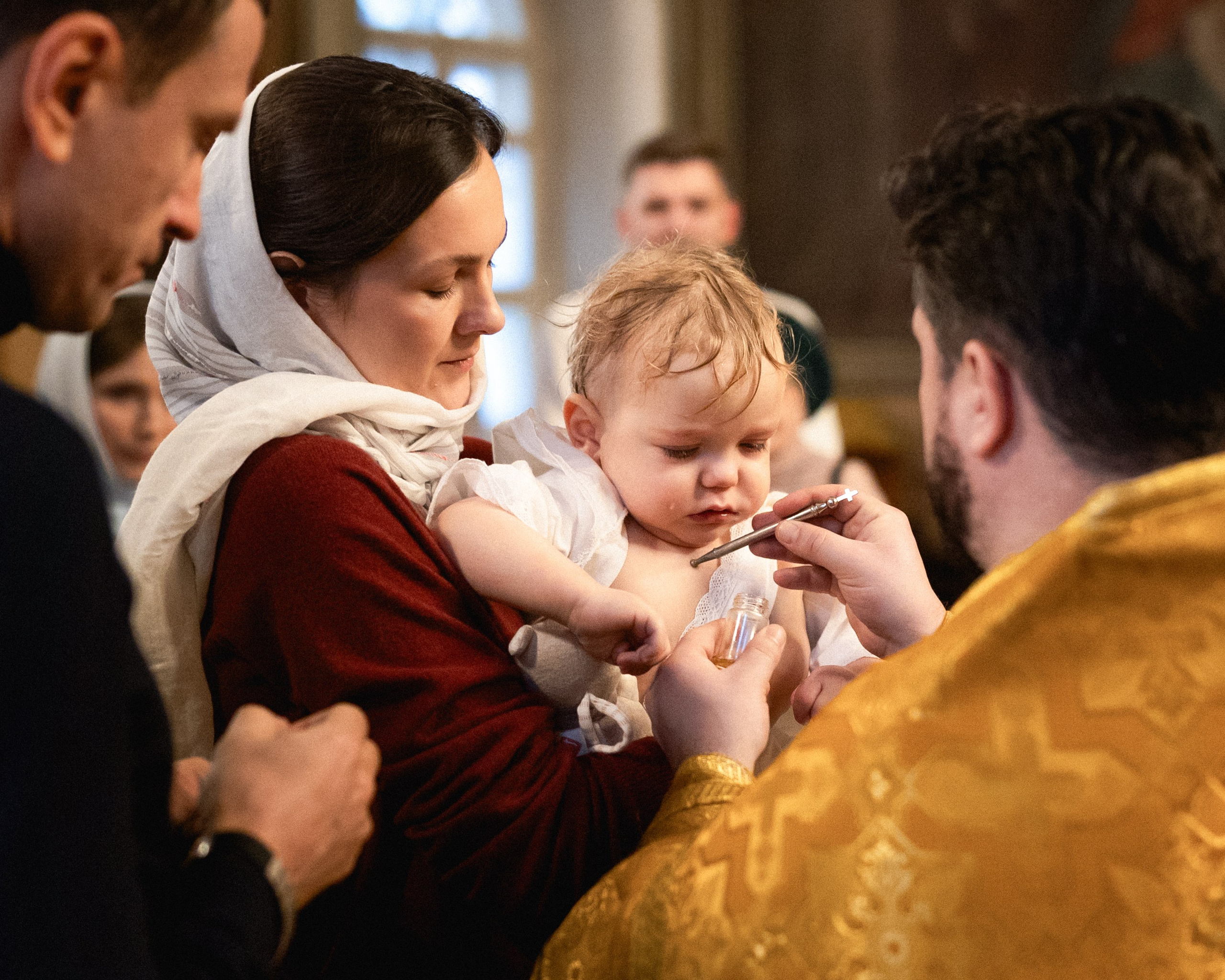 Миропомазание младенца во время крестин в храме