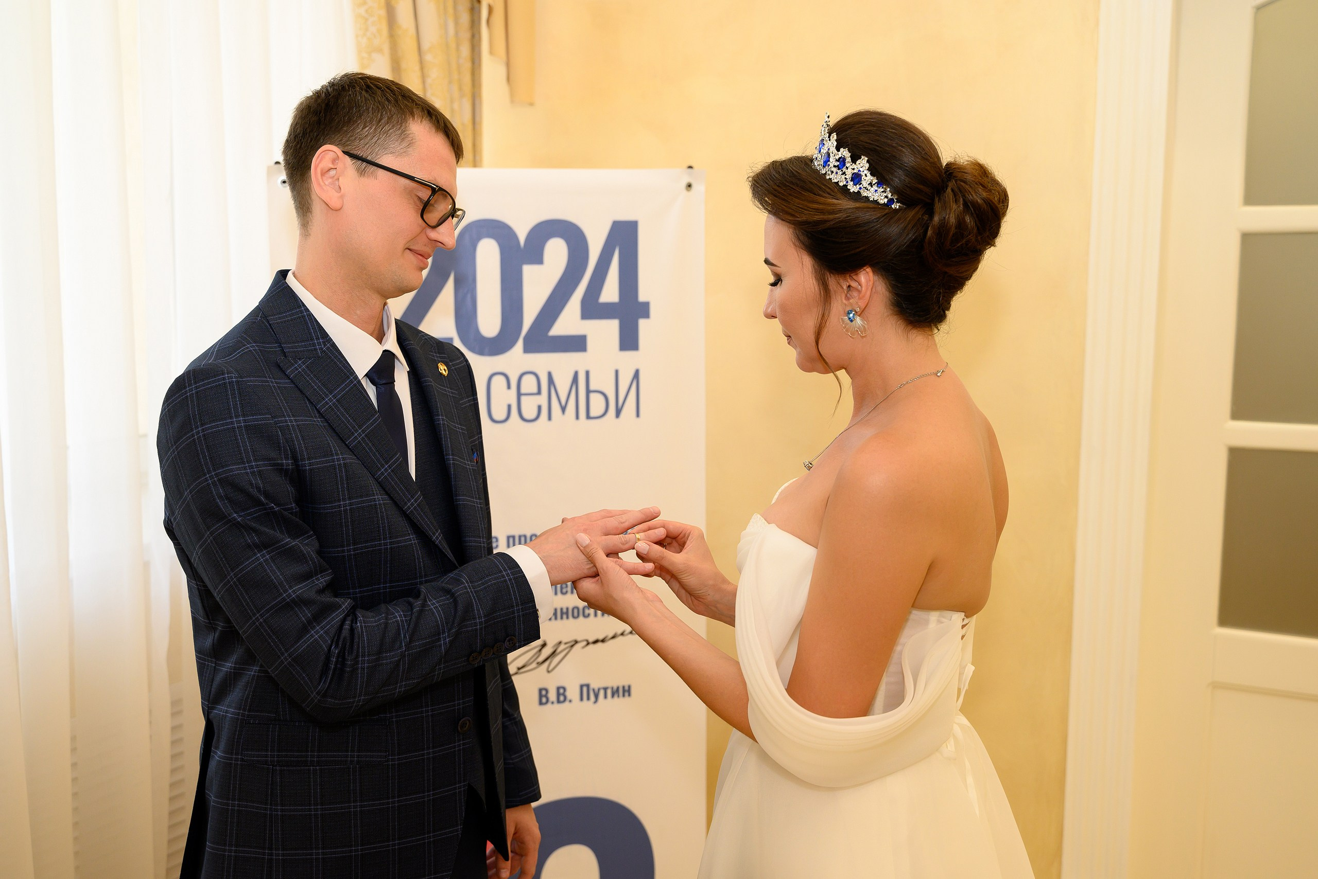 Невеста надевает кольцо жениху.