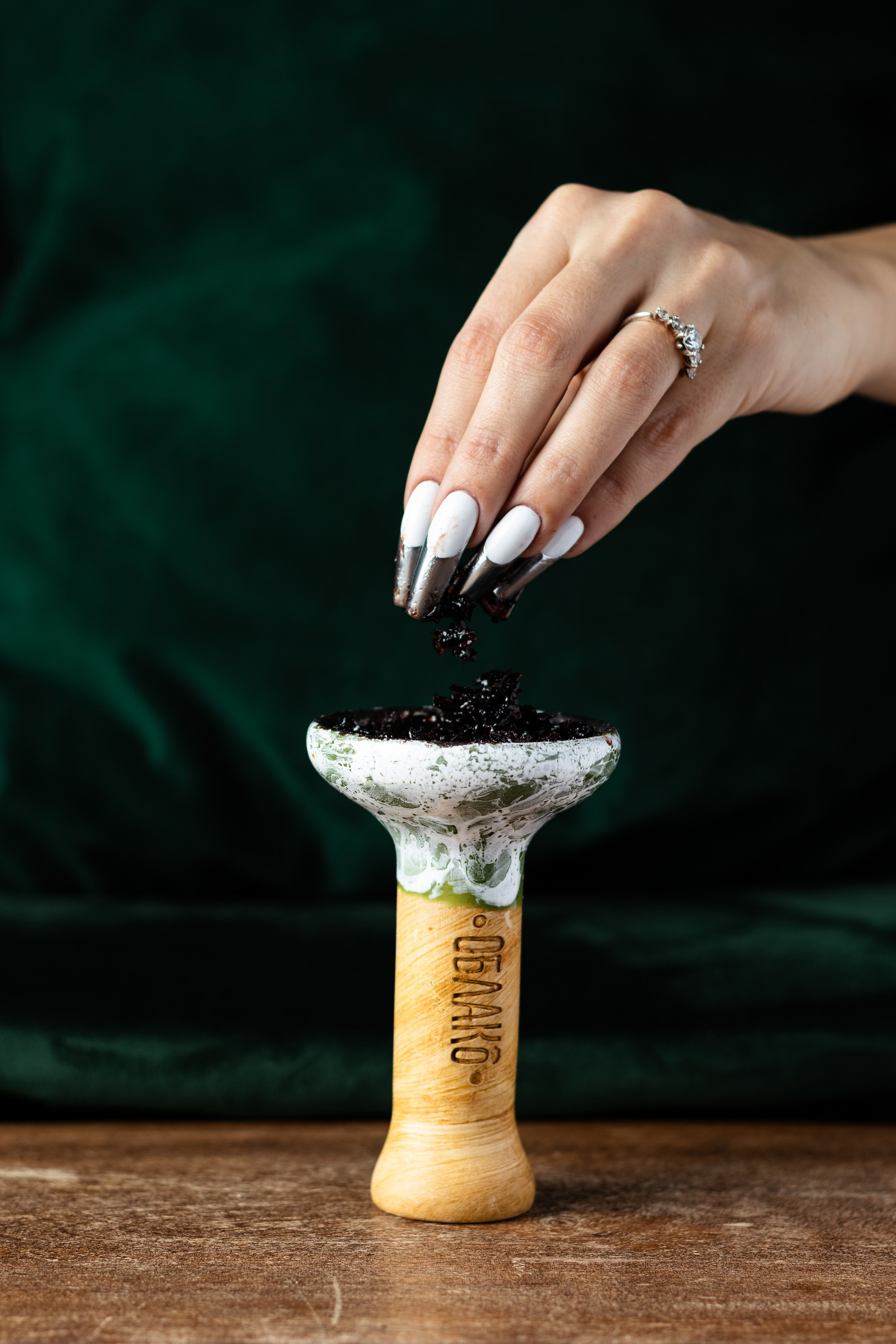 Девушка насыпает табак для кальяна