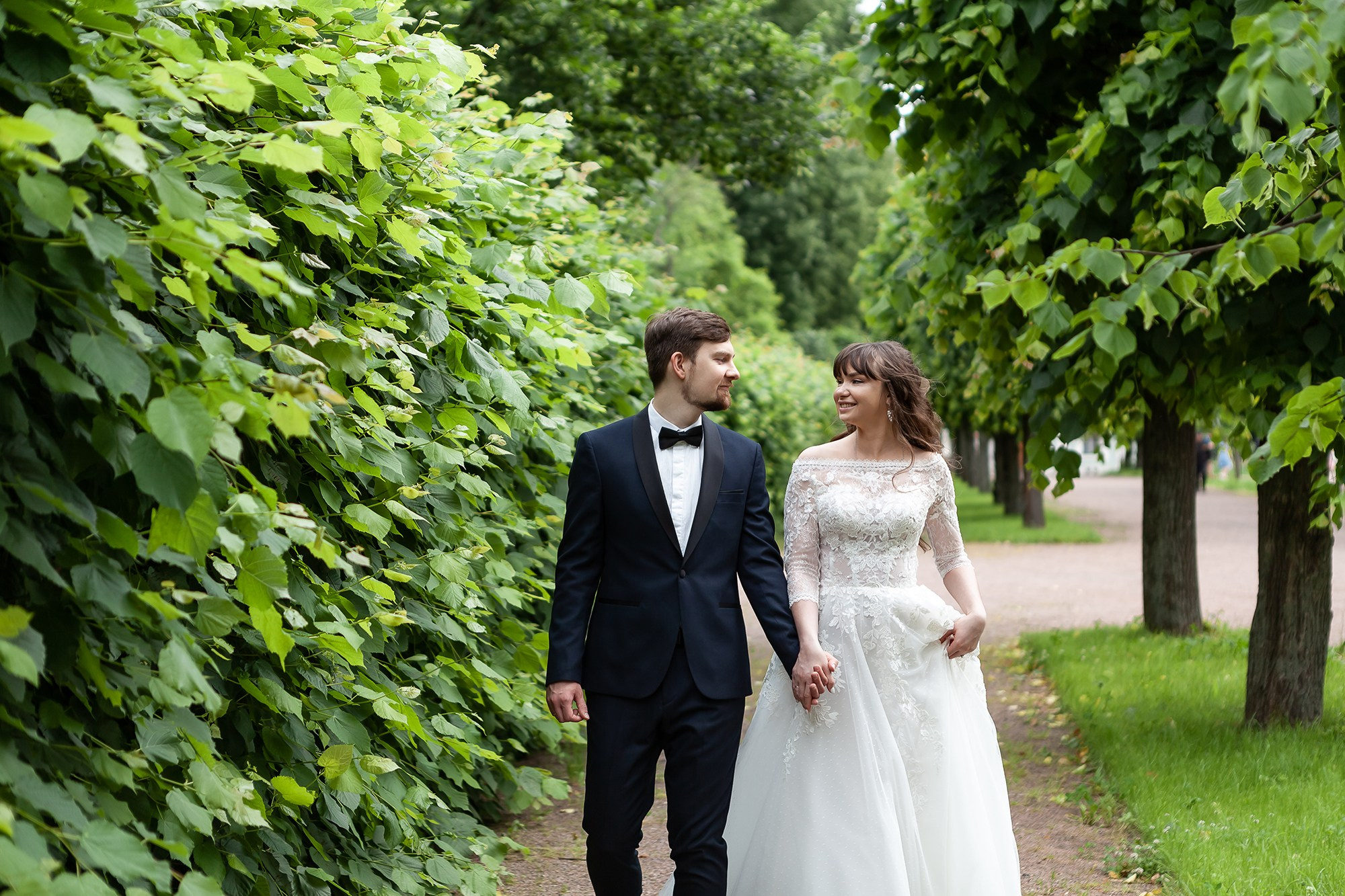 Жених и невеста гуляют по аллее