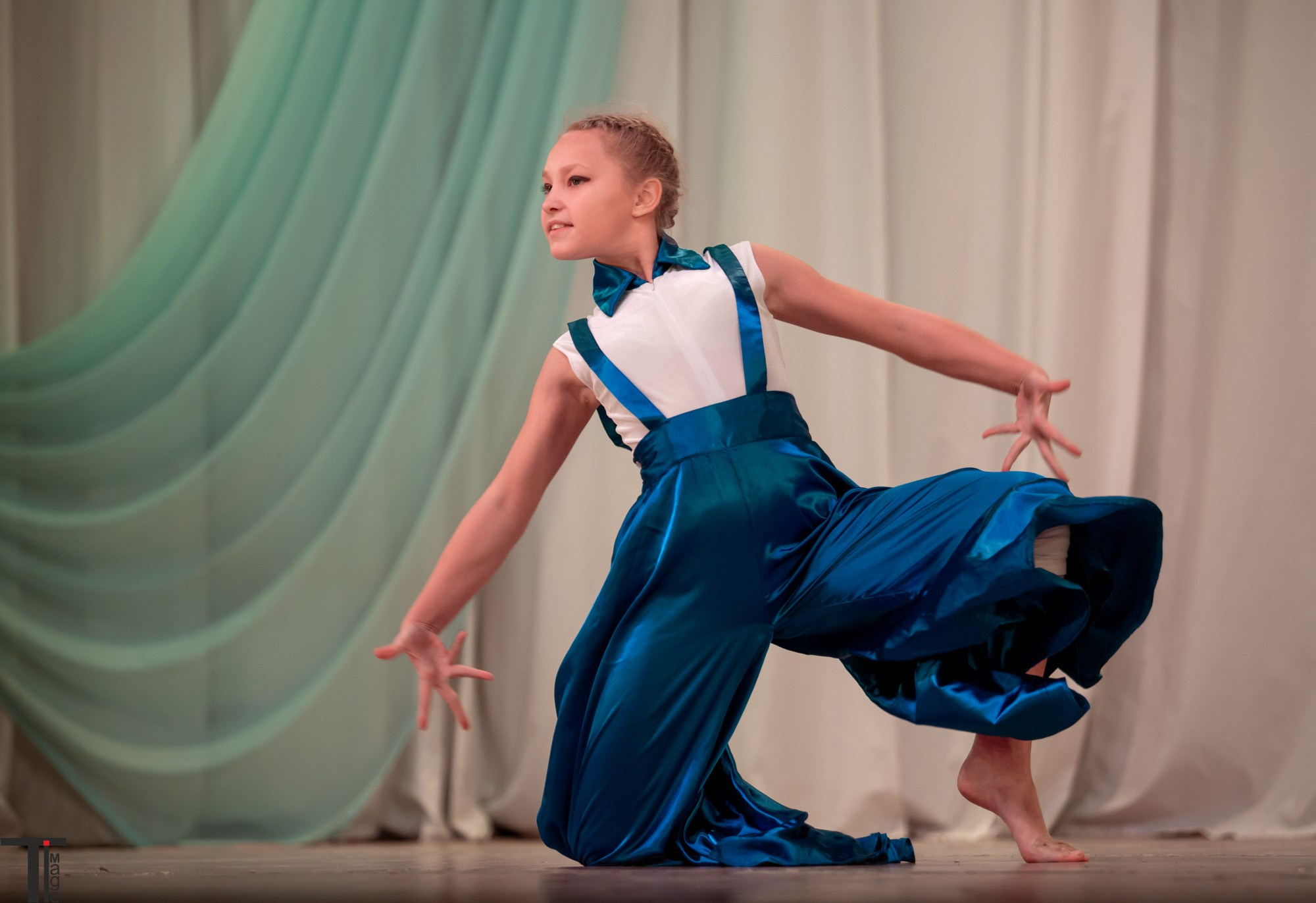 Девушка танцует современный танец в синем платье