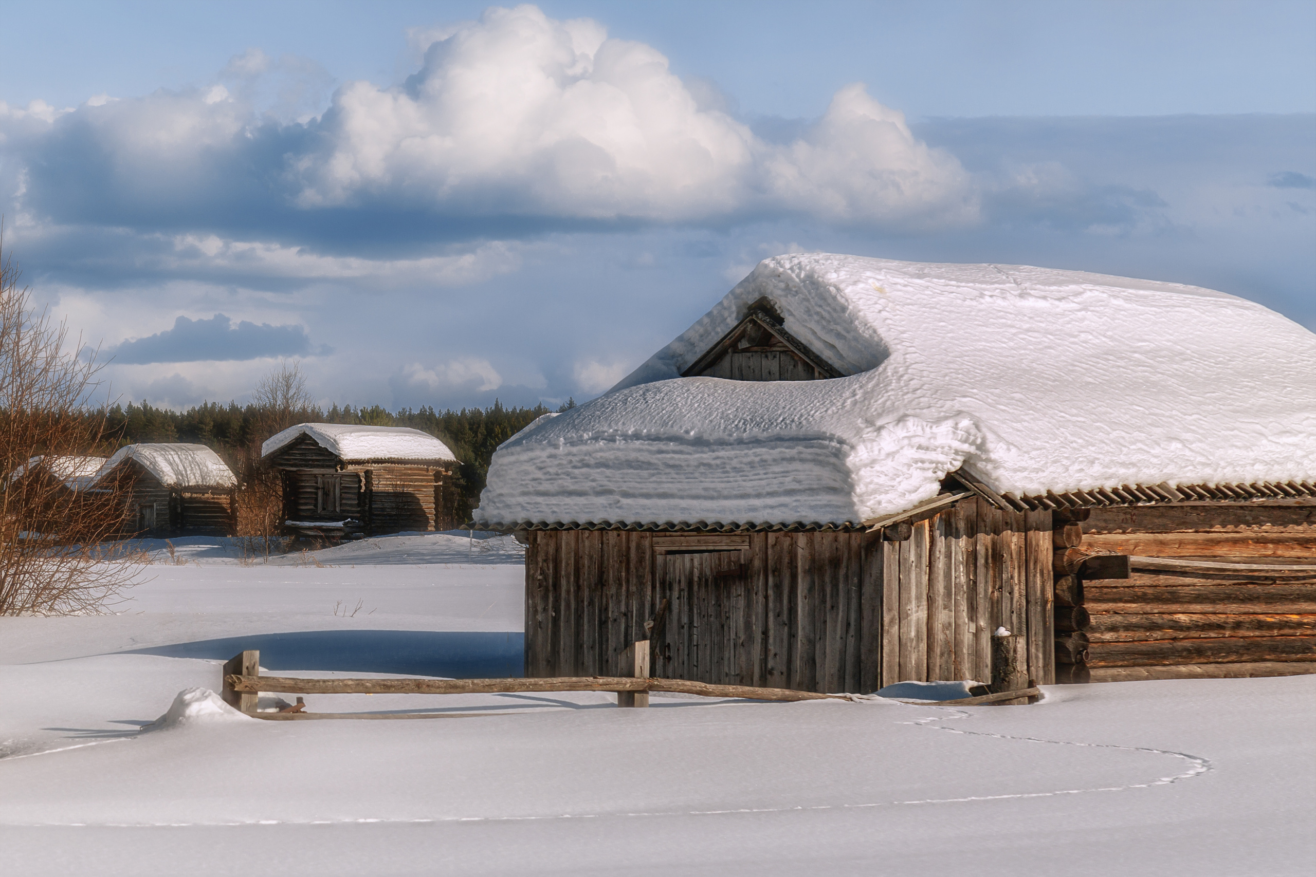 Крыши деревенских домов, занесенные снегм.
