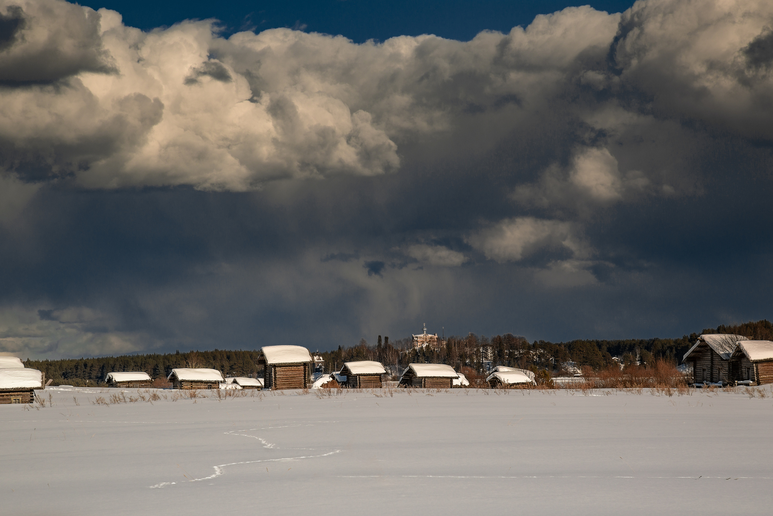 Деревянные амбары, занесенные снегом. Снежные облака, 