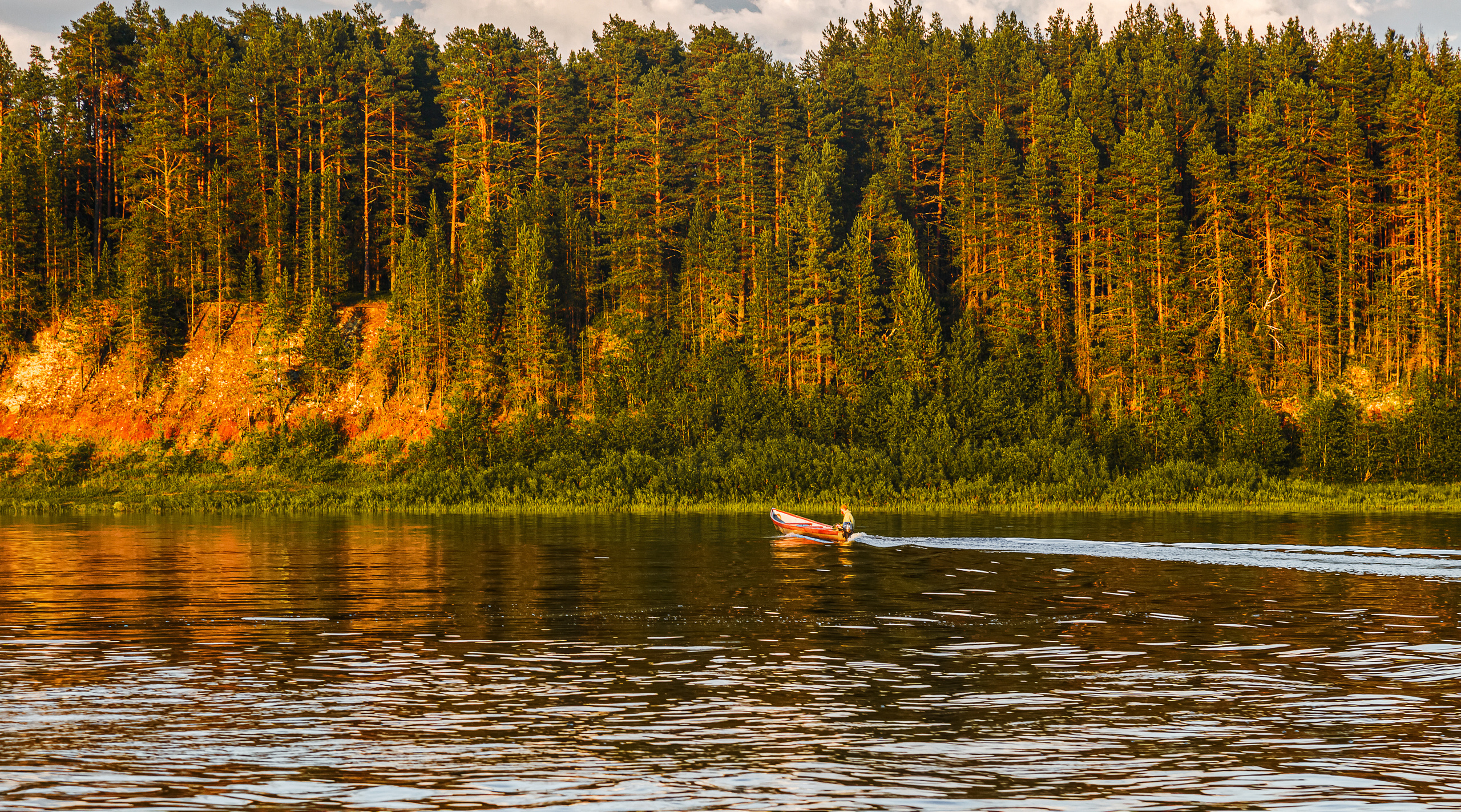 Река Пинега, лодка с движется по реке. Лес на закате.