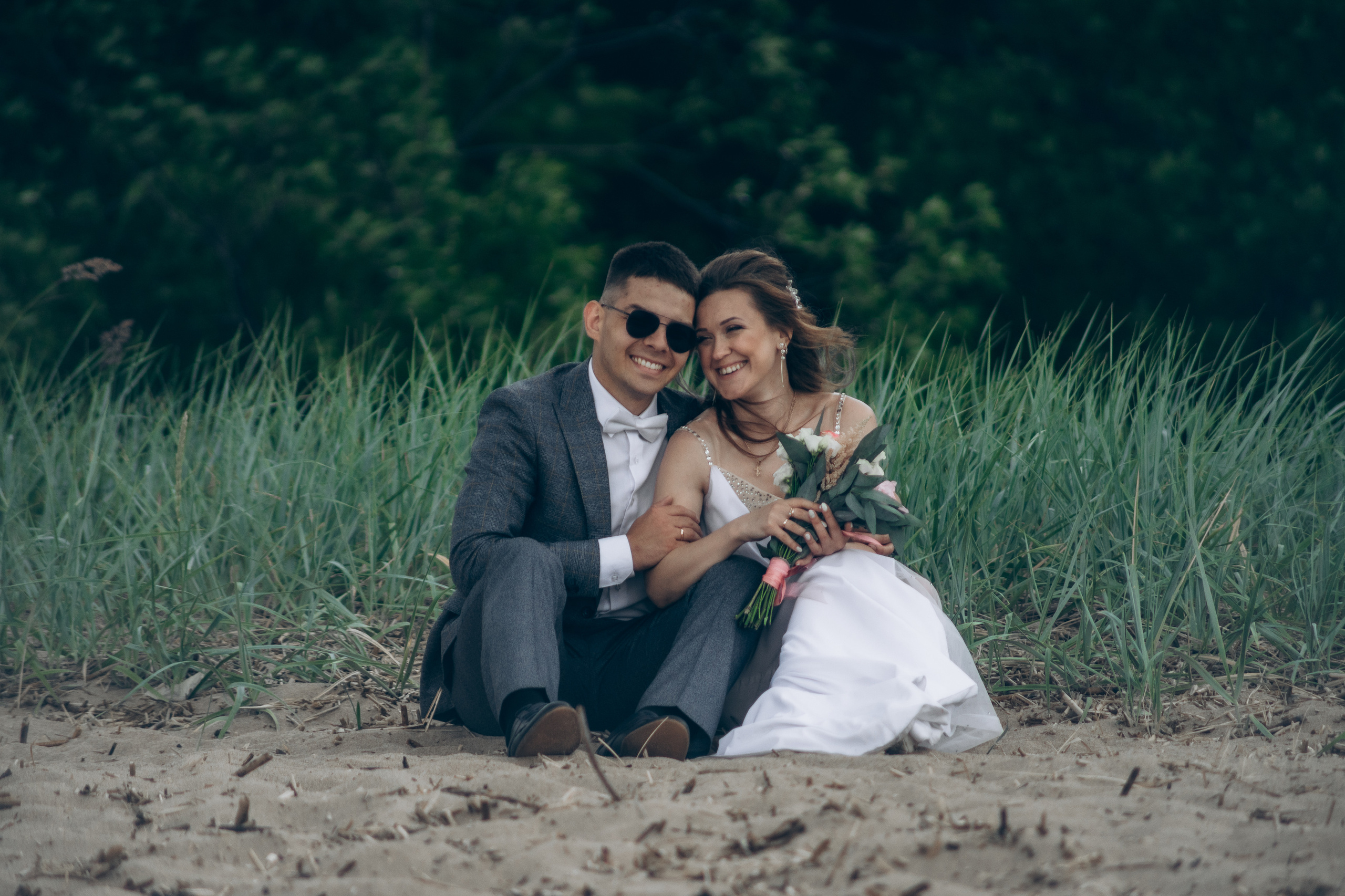 Жених и невеста сидят на берегу залива в Корнштадте