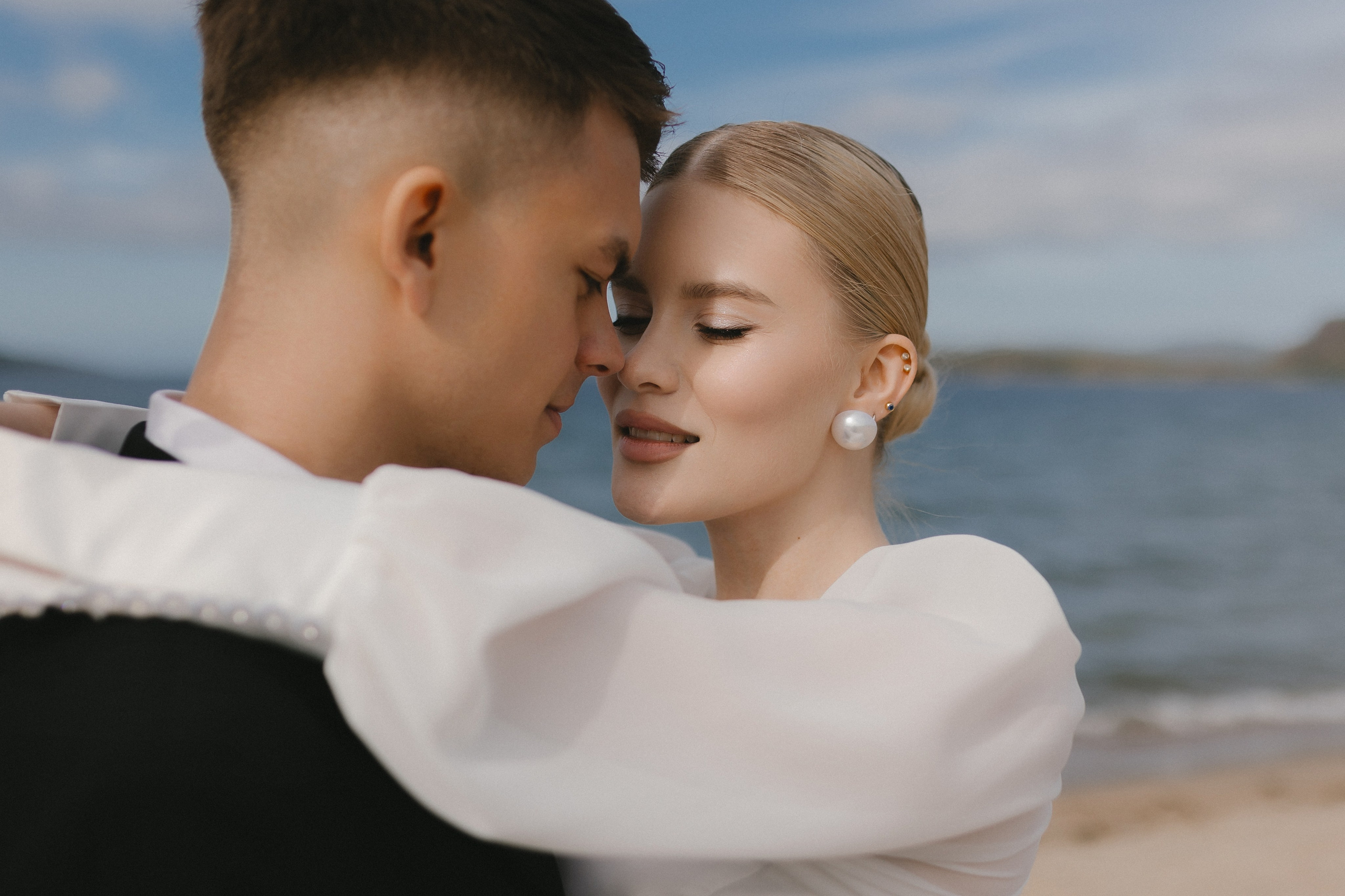 Красивый портрет молодой пары на фоне бескрайнего Баренцева моря.