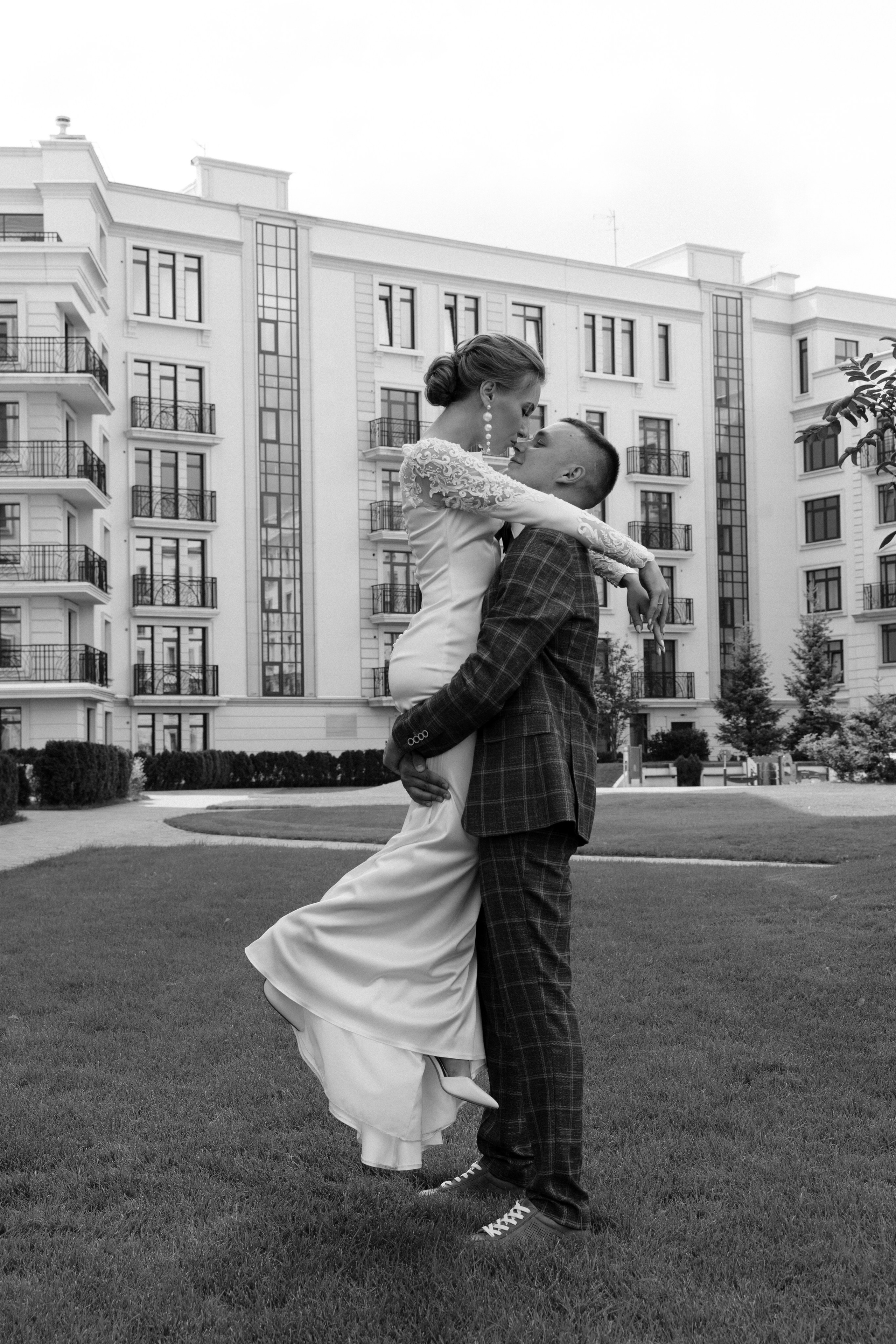 Жених поднял невесту и целует на улице