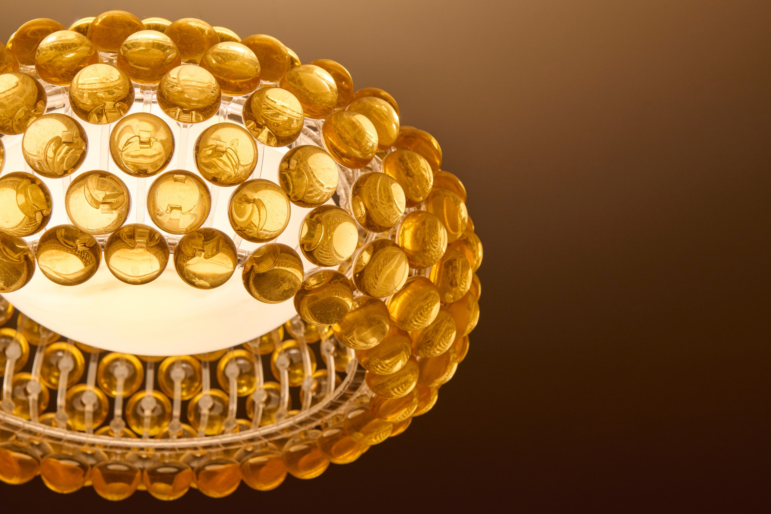 Стеклянная люстра крупным планом, тёплый свет / Люстра с янтарными элементами, акцент интерьера