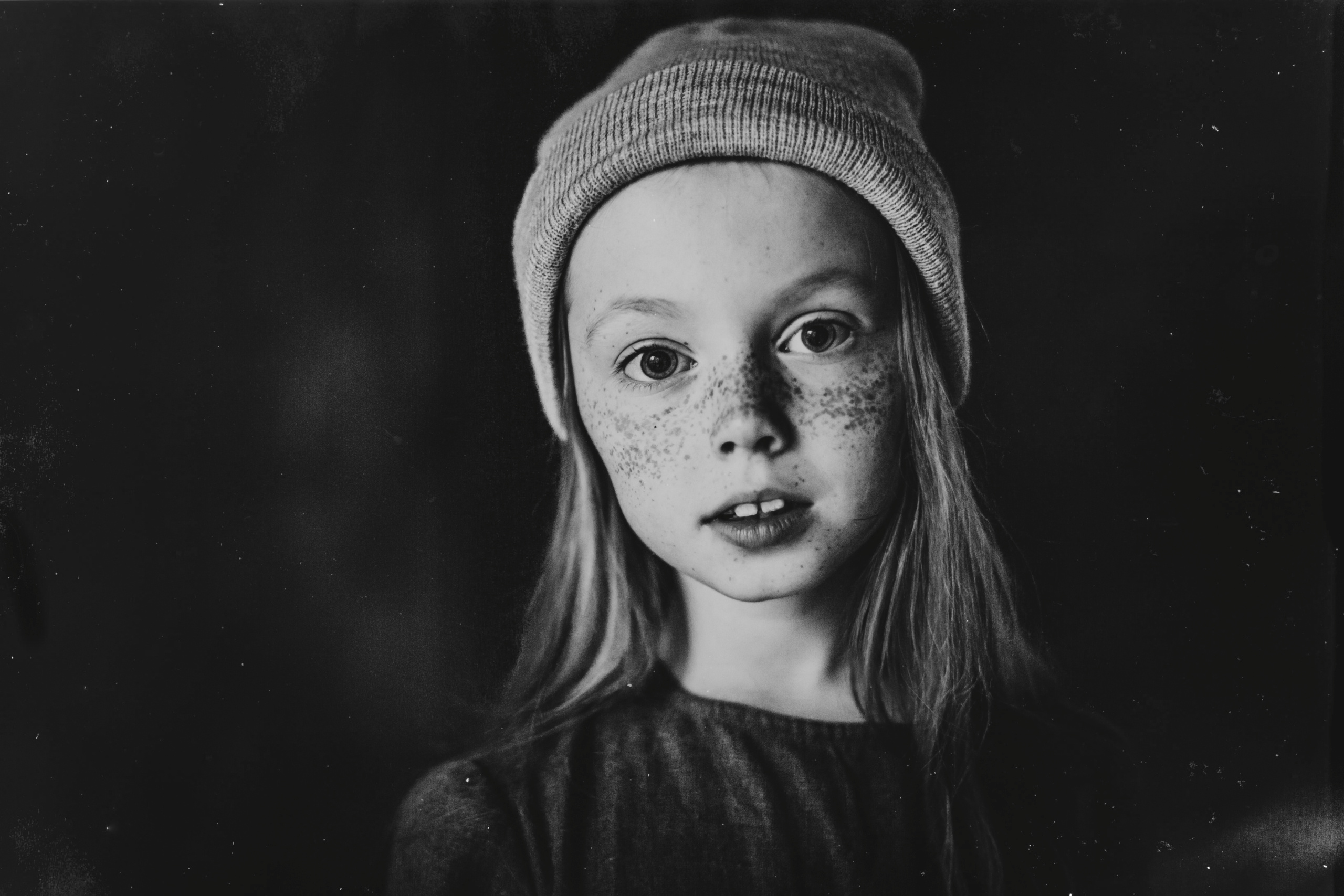 черно-белый портрет веснушчатой девочки в шапке