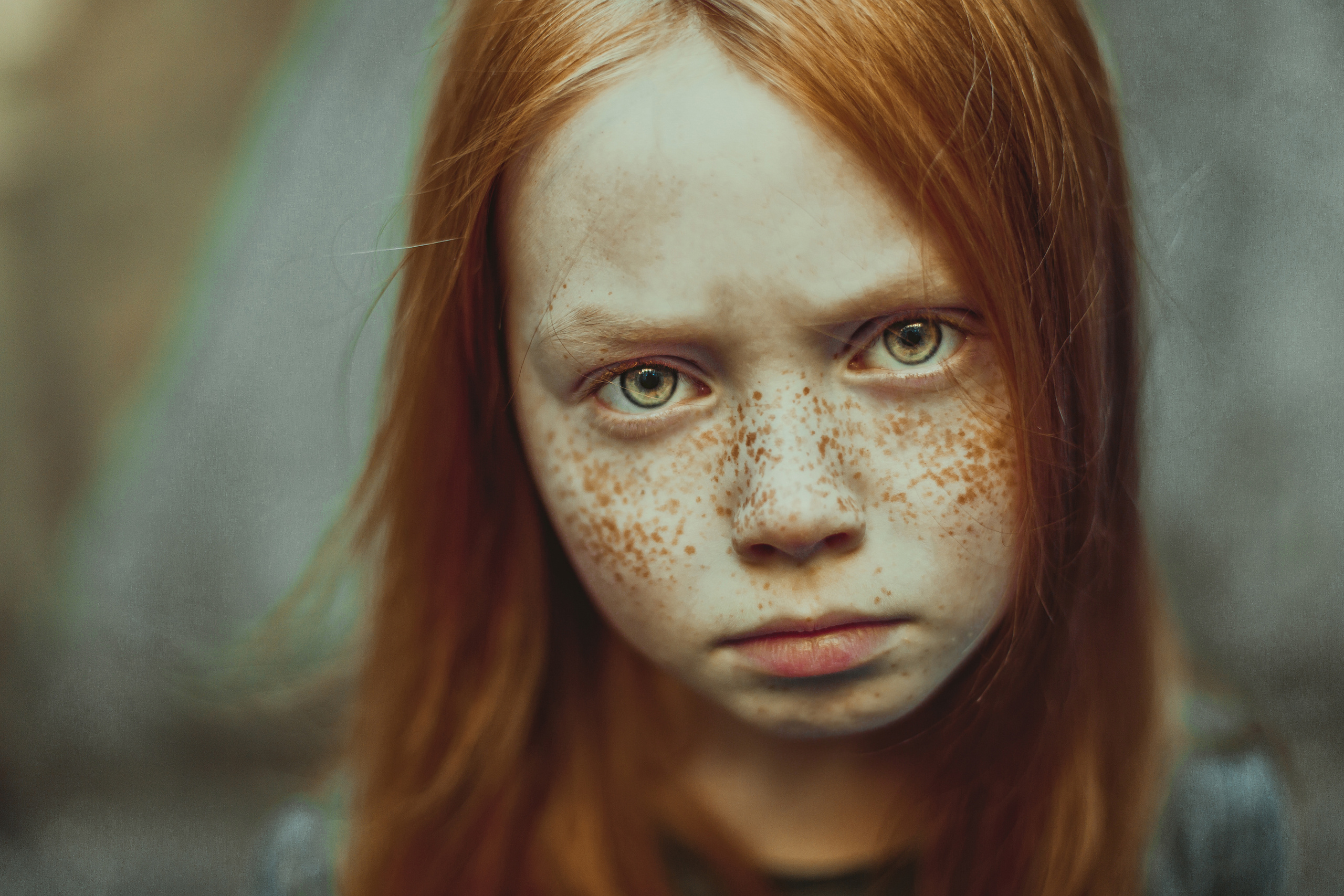 портрет серьезной рыжей веснушчатой девочки с желтыми глазами
