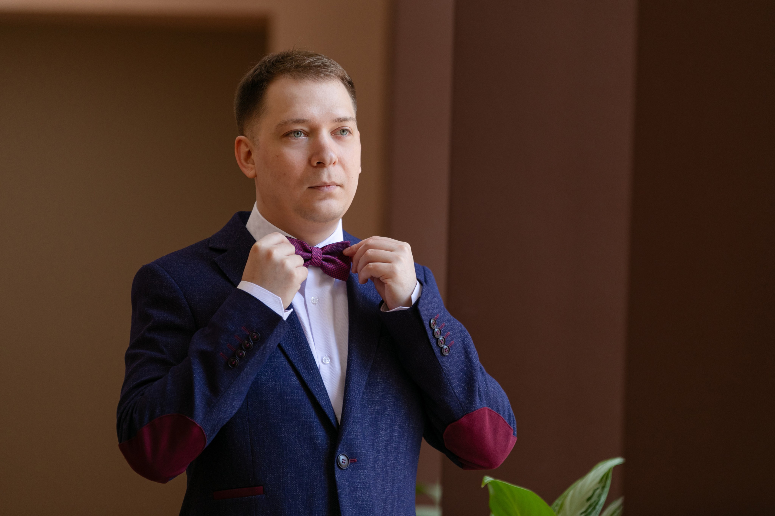 Жених готовиться к свадьбе поправляет бабочку