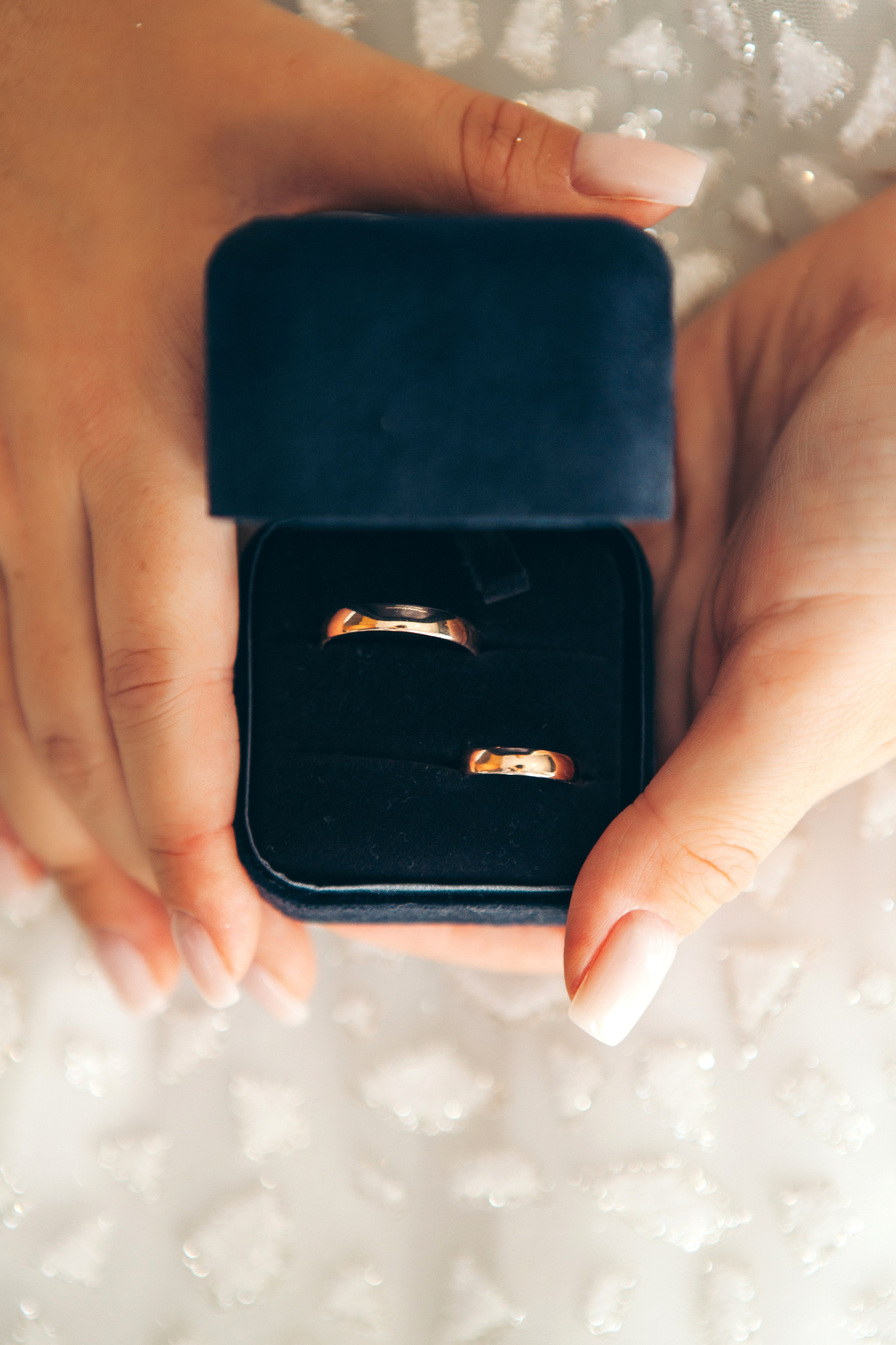 невеста держит в руках свадебные кольца