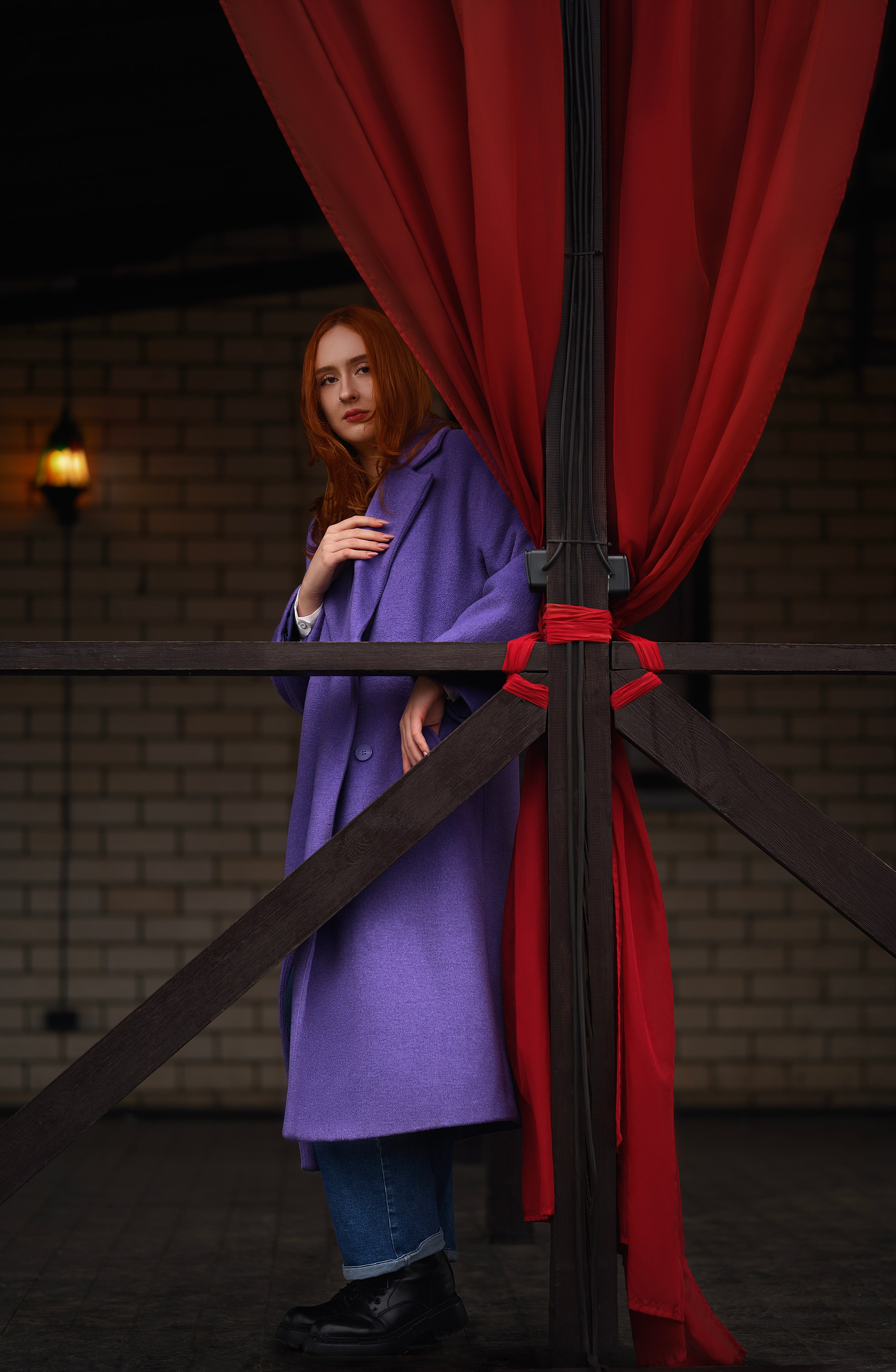 Портрет в Волгодонске: девушка с рыжими волосами в фиолетовом пальто. Фон — здание с красными шторами. Фото от Е. Жуйковой.