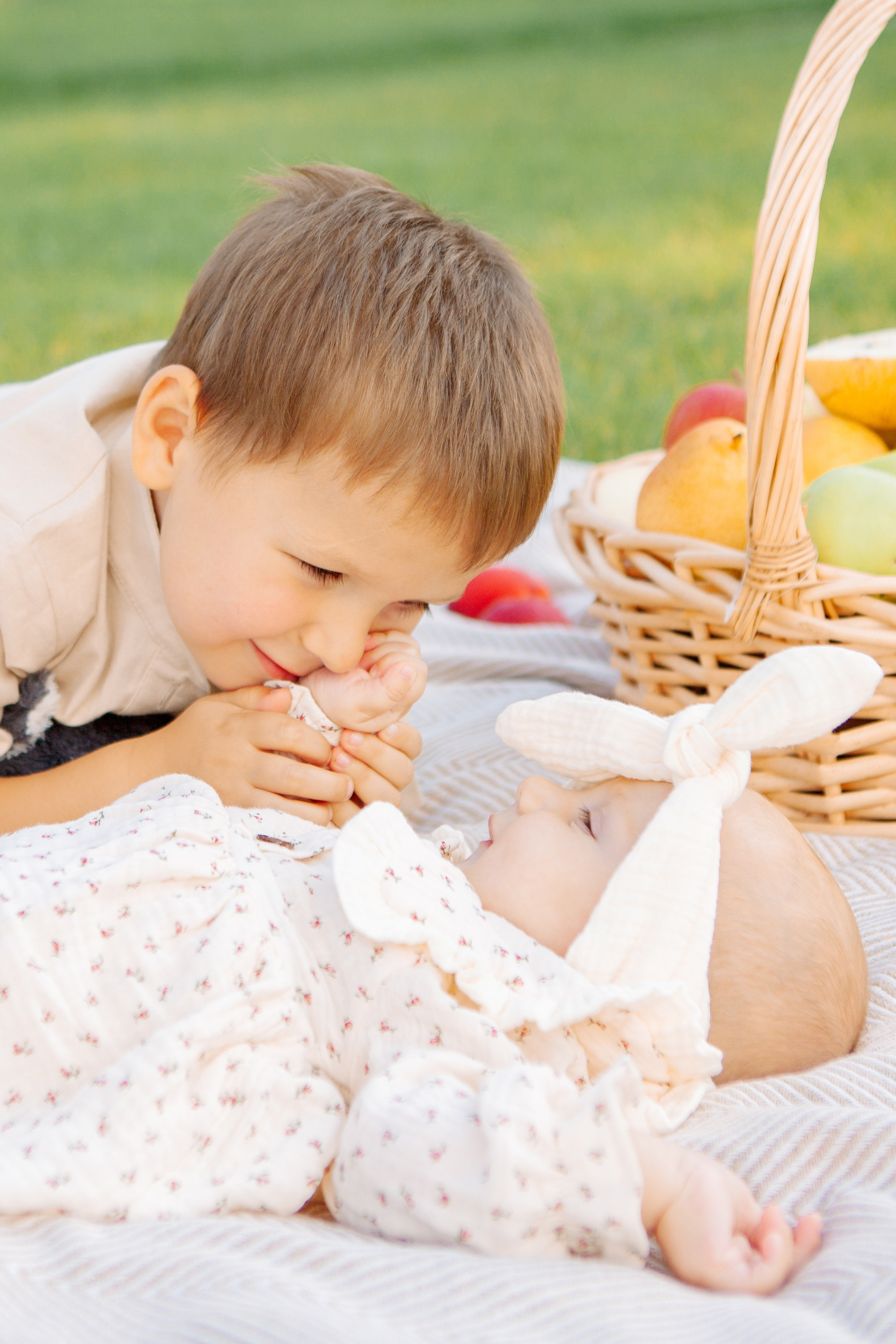  братик любуется младшей сестренкой на фоне фруктов летом