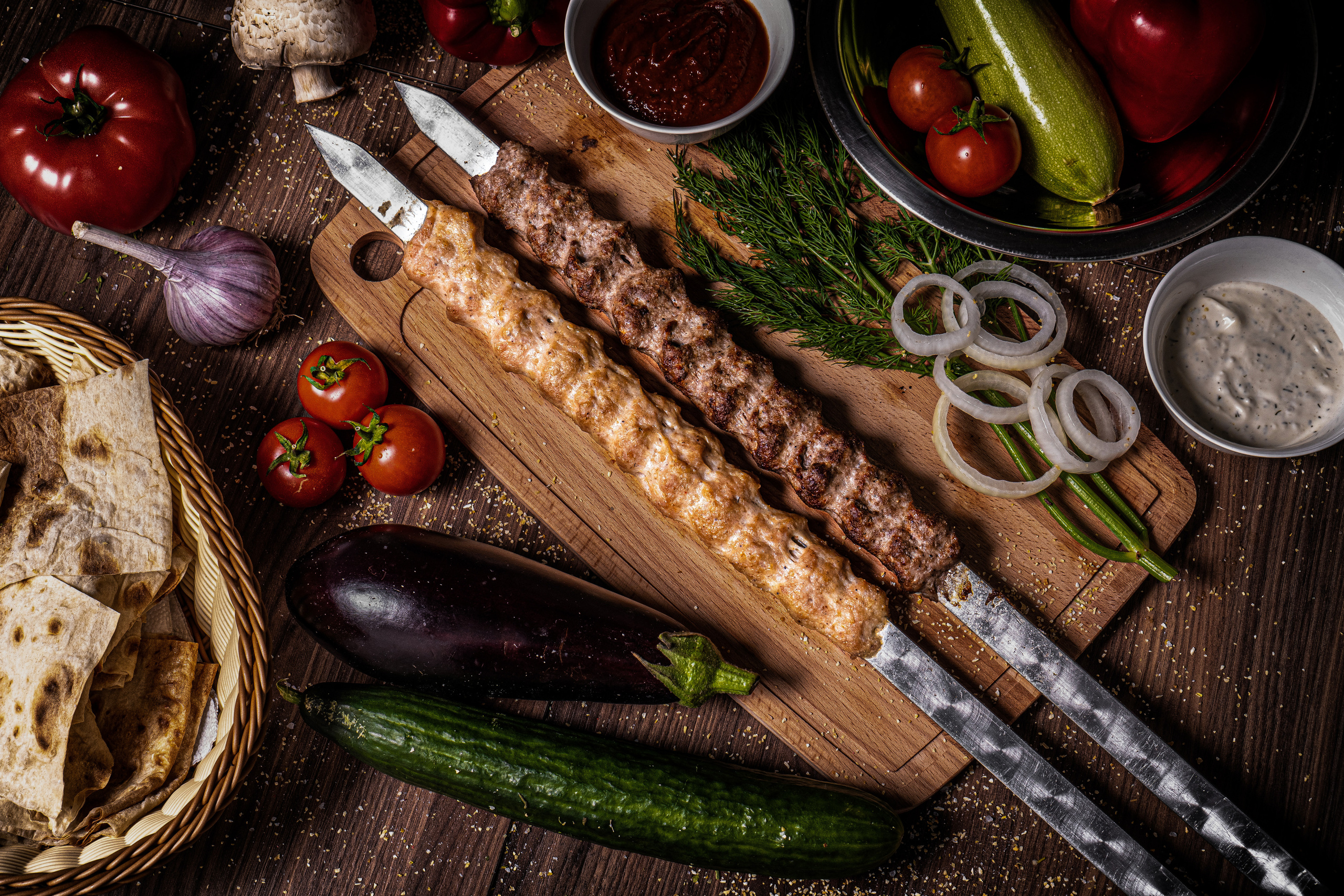 два шампура с люля-кебаб на сервированном столе