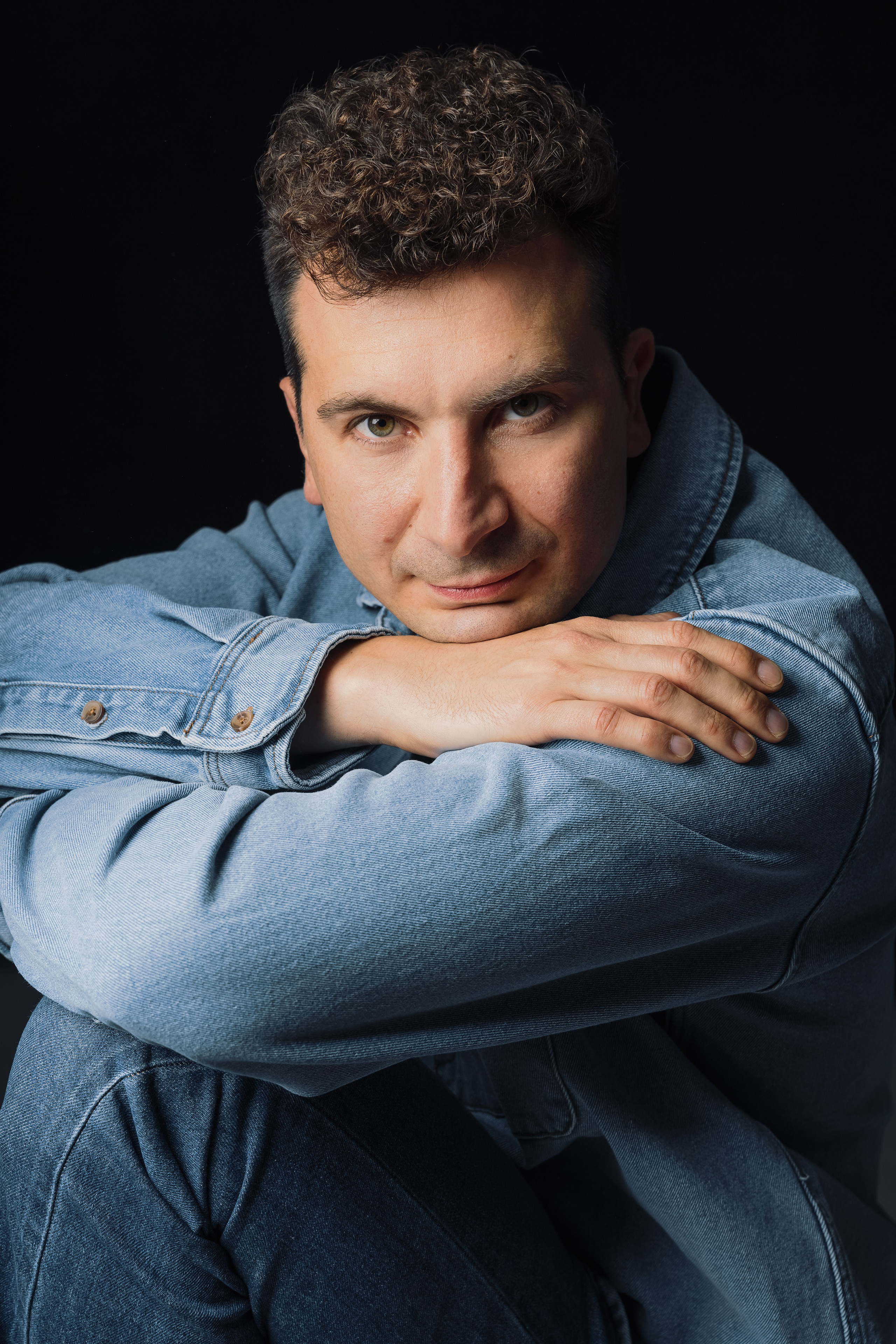 Портрет мужчины в джинсовой рубашке на темном фоне