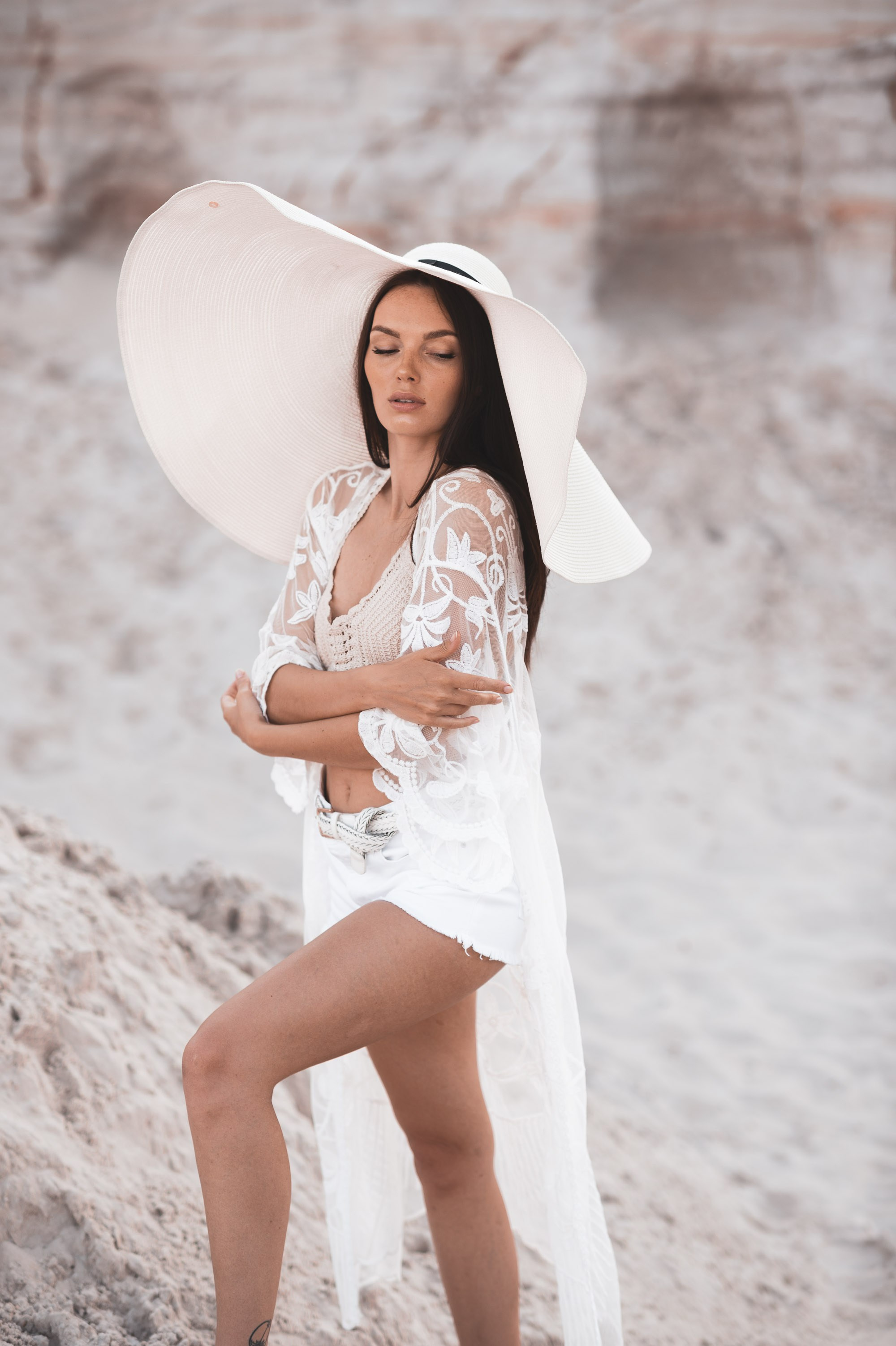 красивая молодая девушка в шляпе с широкими полями в песчаном карьере 