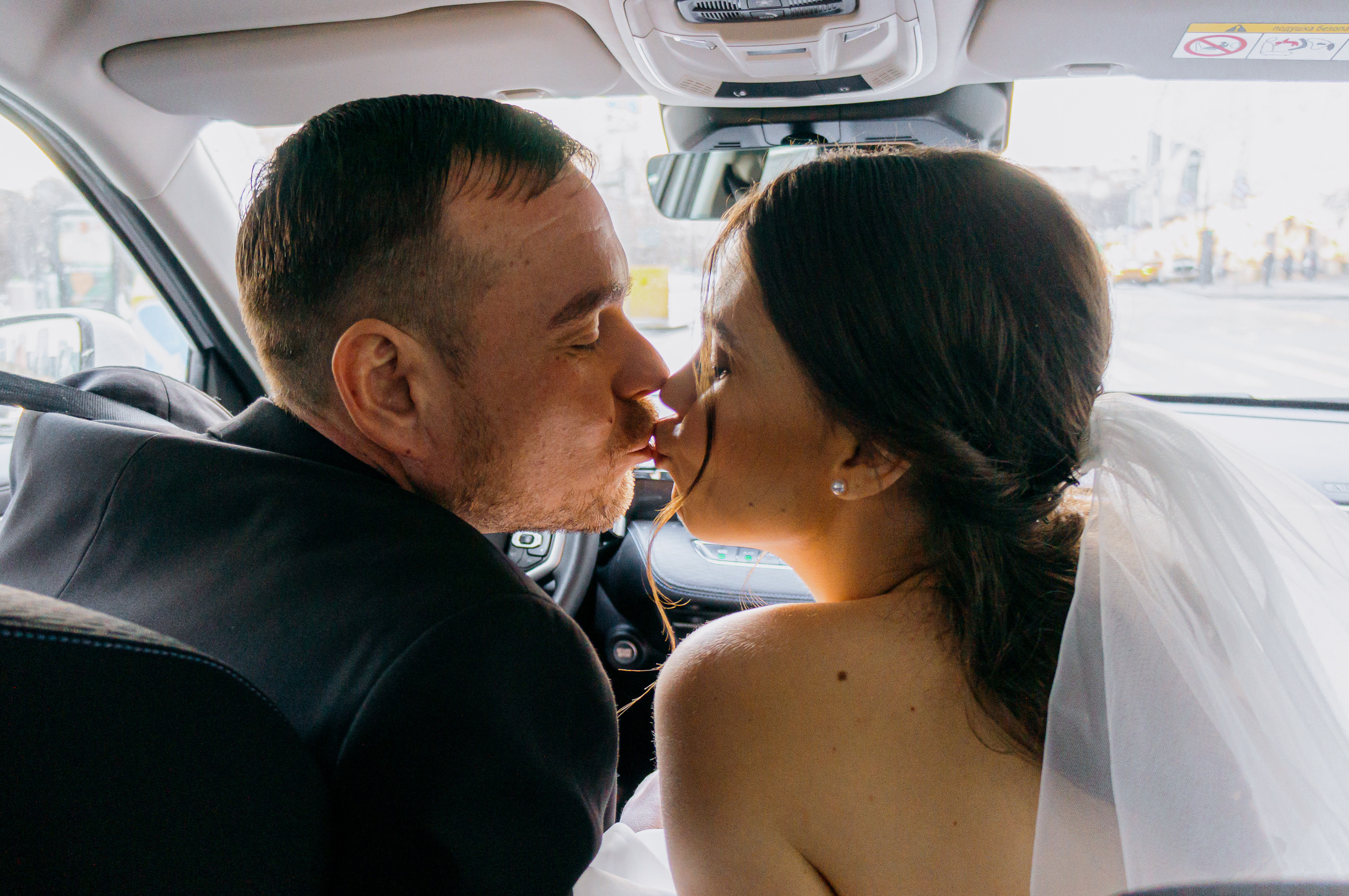 влюбленная пара после ЗАГСа целуется в машине