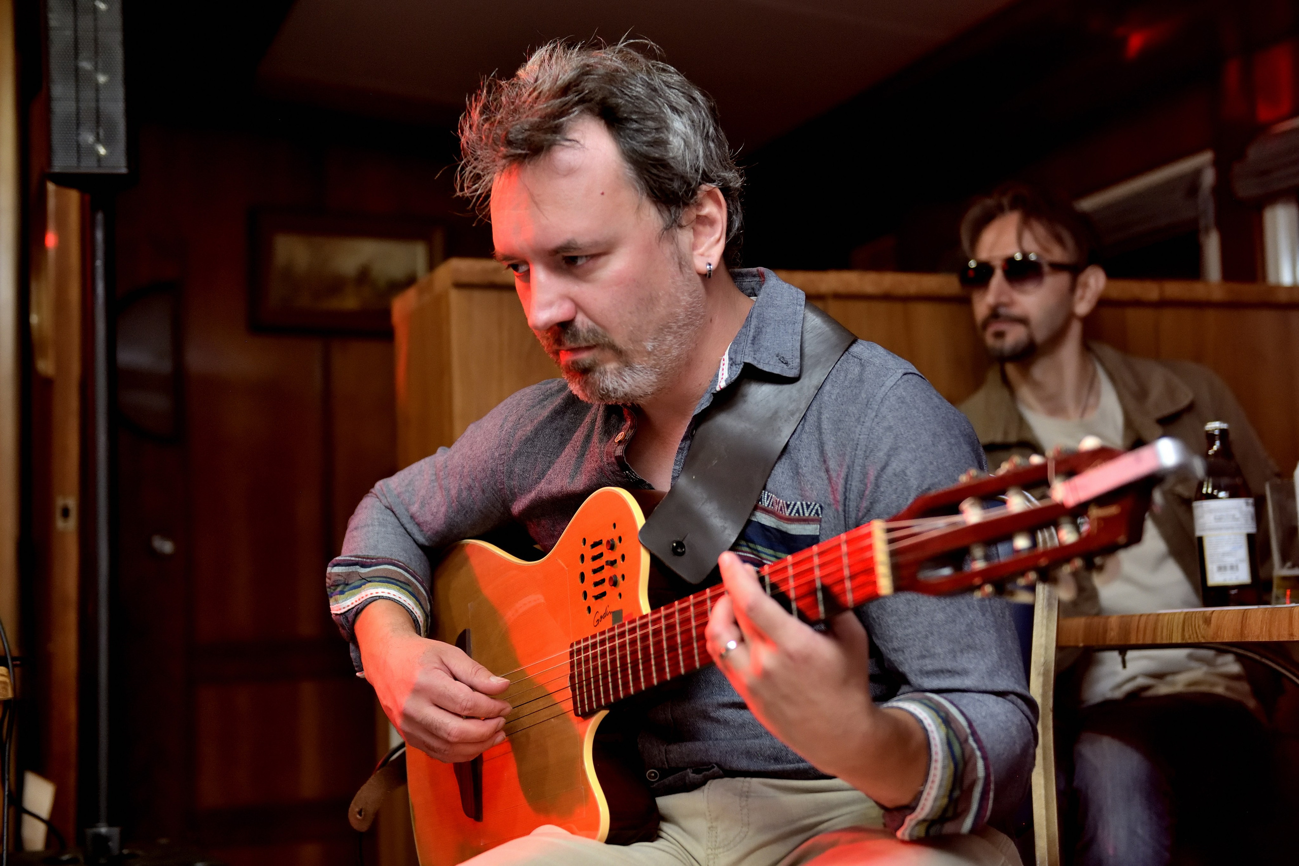 "Гитарист увлеченно играет на гитаре во время концерта".