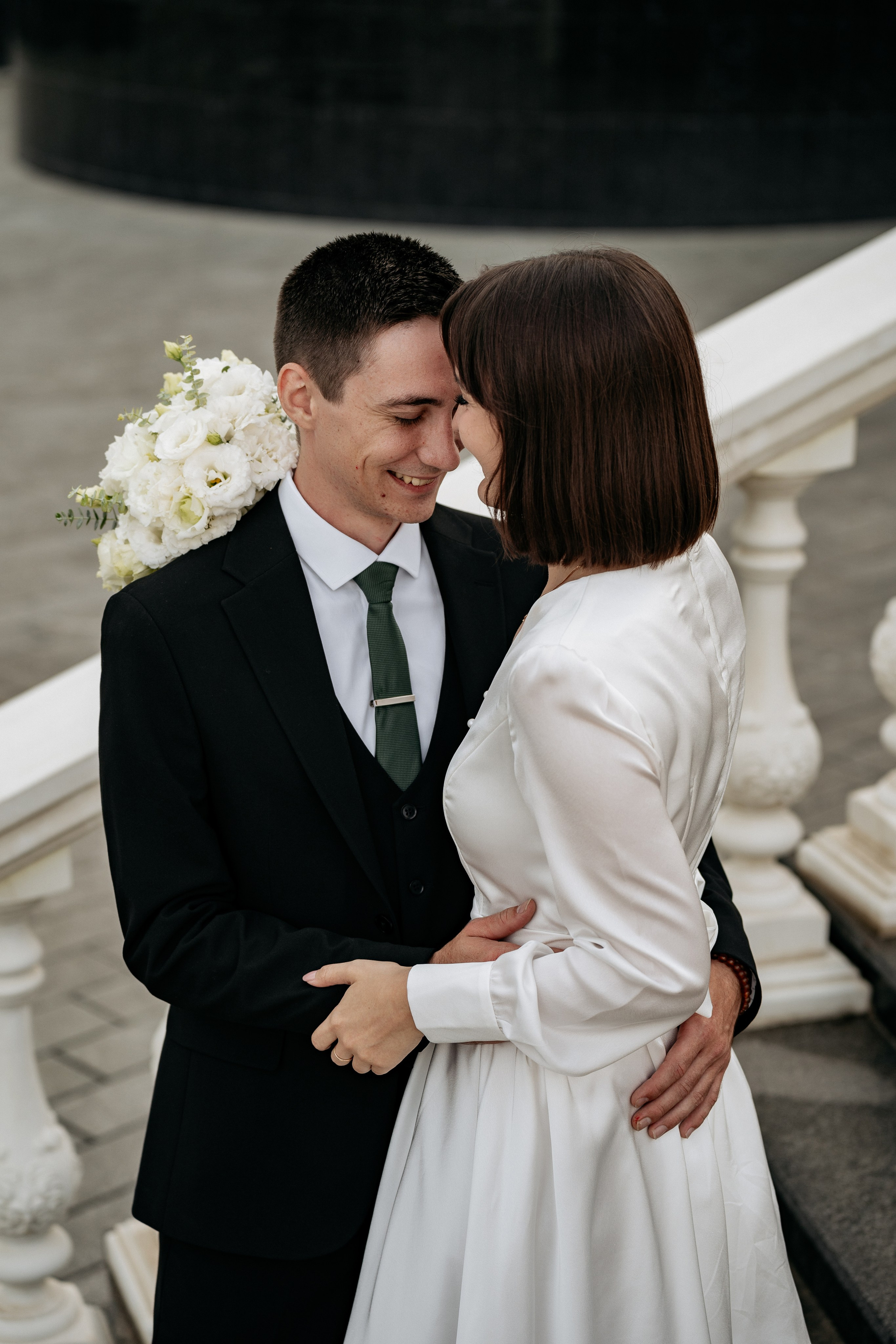 Свадебная фотосессия в Новороссийске. Искренний смех жениха и невесты во время прогулки по набережной.