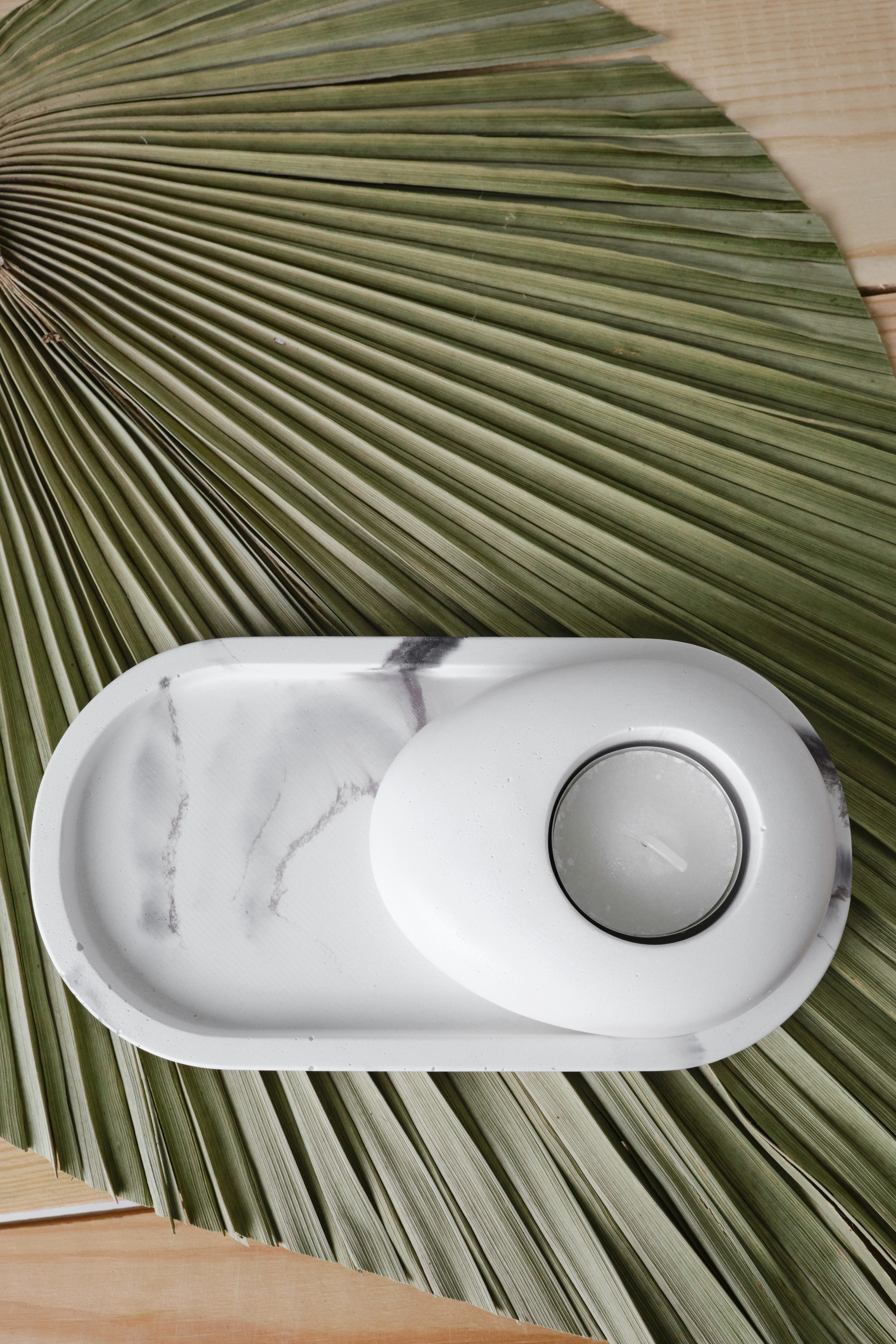 фотография для контента магазина бетонный подсвечник на подносе и пальмовом листа