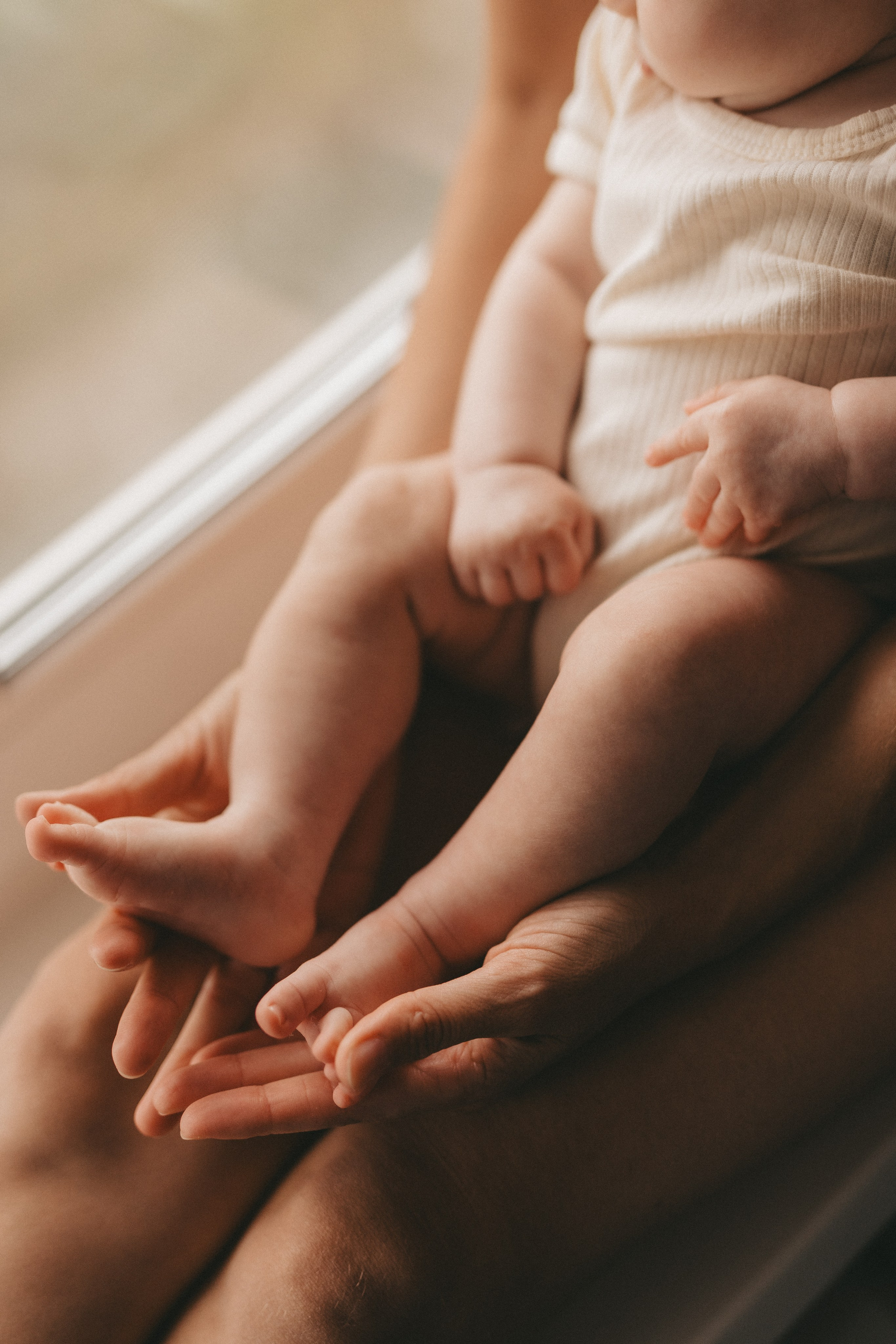 крупным планом ножки младенца в руках мамы