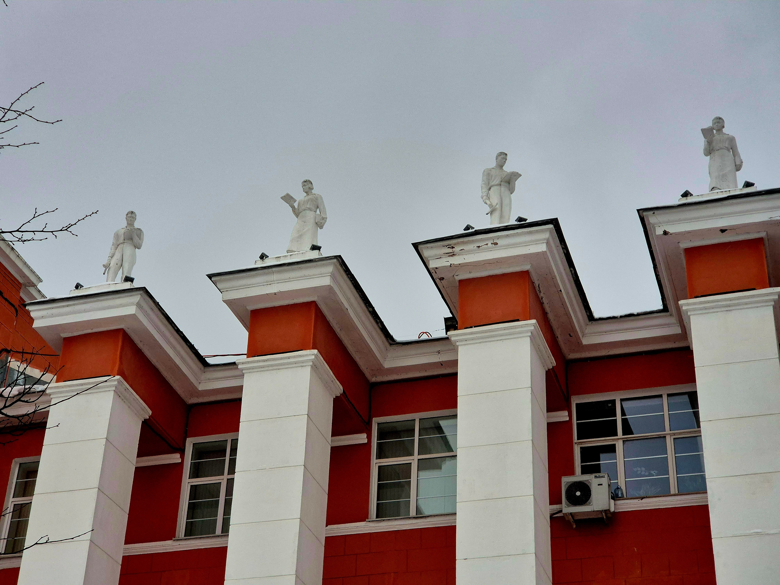 Соверемнные титаны стоят и взирают на студентов с крыши ВУЗа