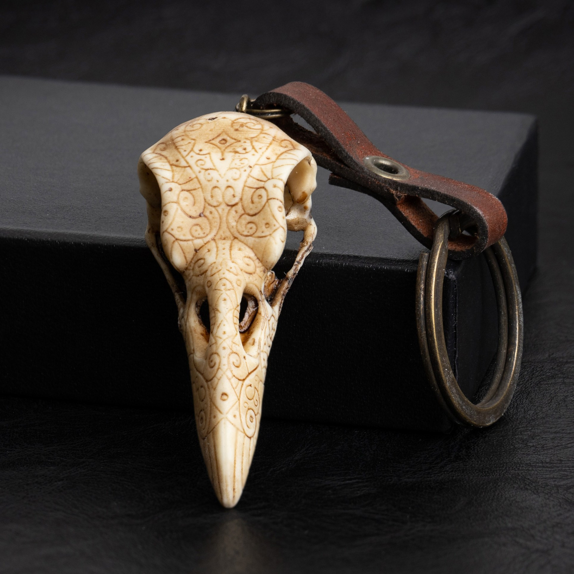 Брелок-череп ворона с кожаной подвеской | Фото на черном фоне для Ozon