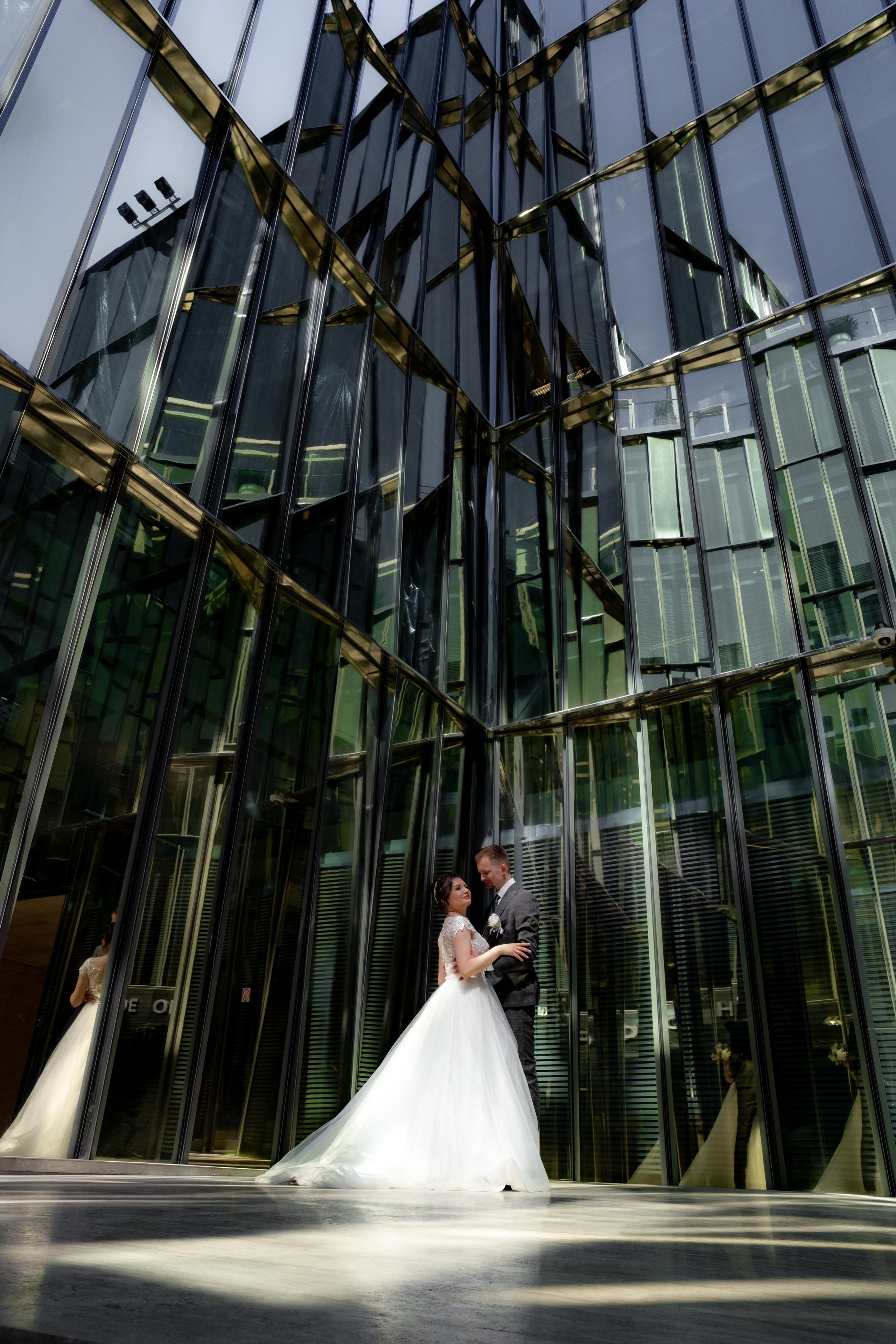 жених и невеста целуются в зеркальном дворике