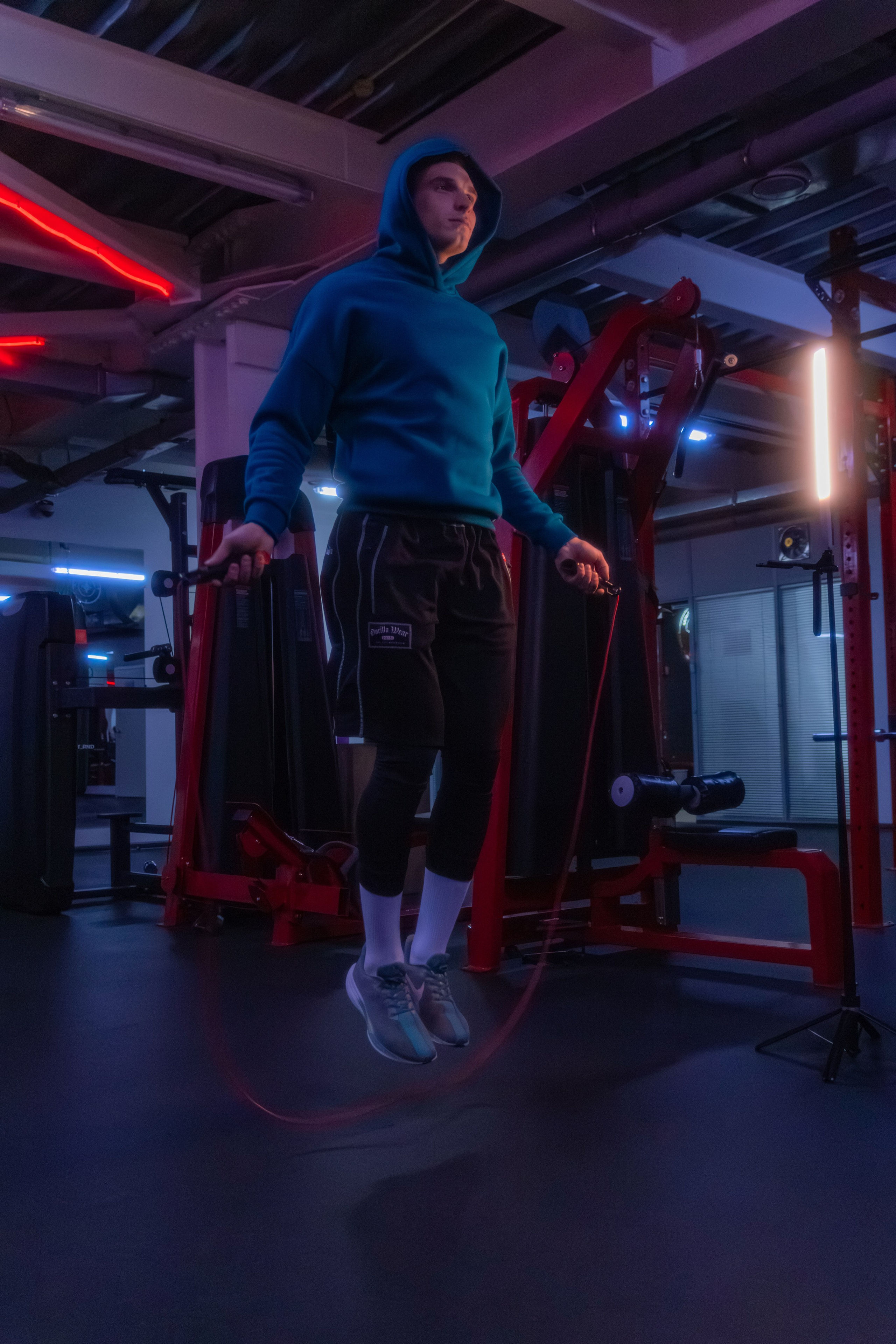 Модный кадр спортивного наставника, где неоновое освещение создает гламурный образ.