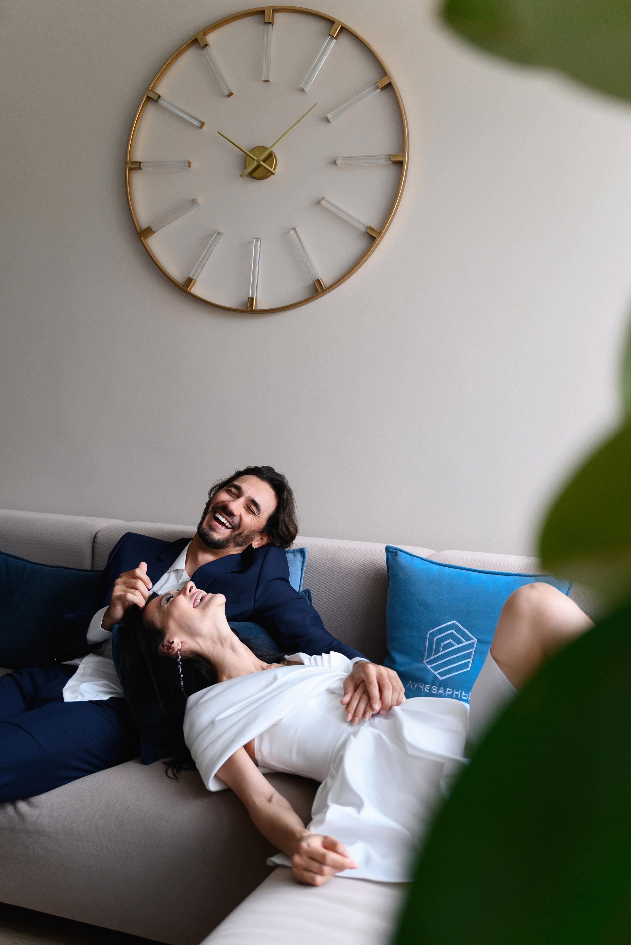 Репортажный кадр где я на молодые не ожидали что их снимают они сидят на диване невеста легла головой на колени к жениху и они смеются 