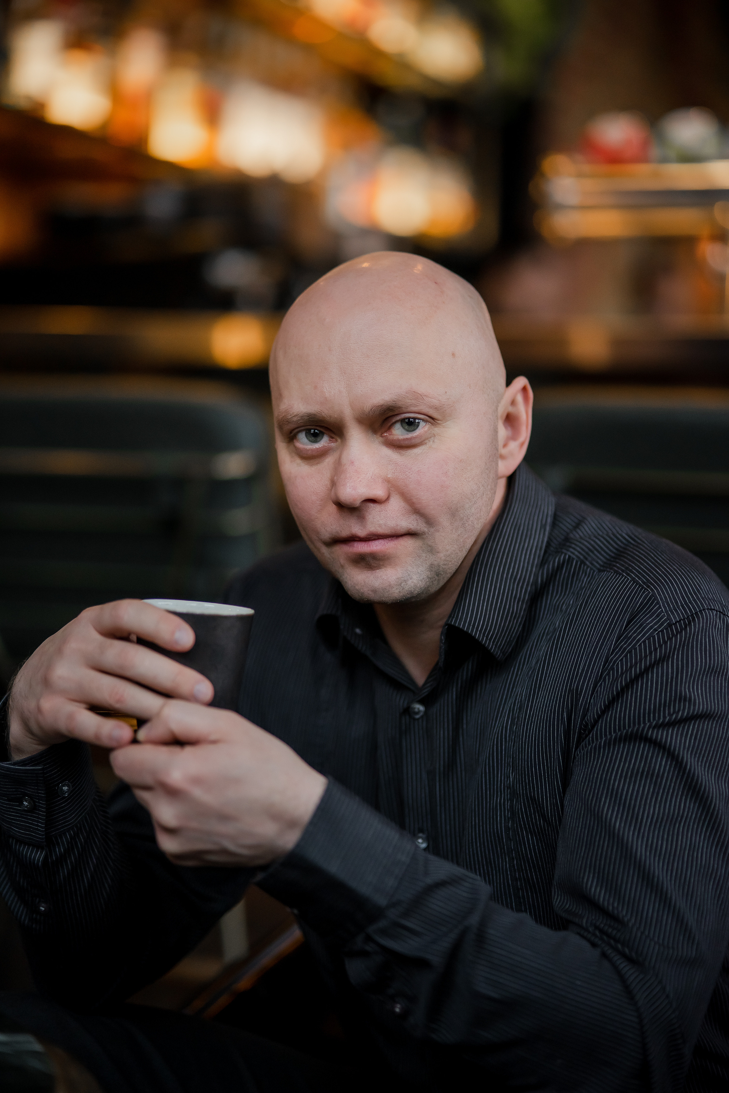 Лысый мужчина средних лет позирует для мужского портрета 