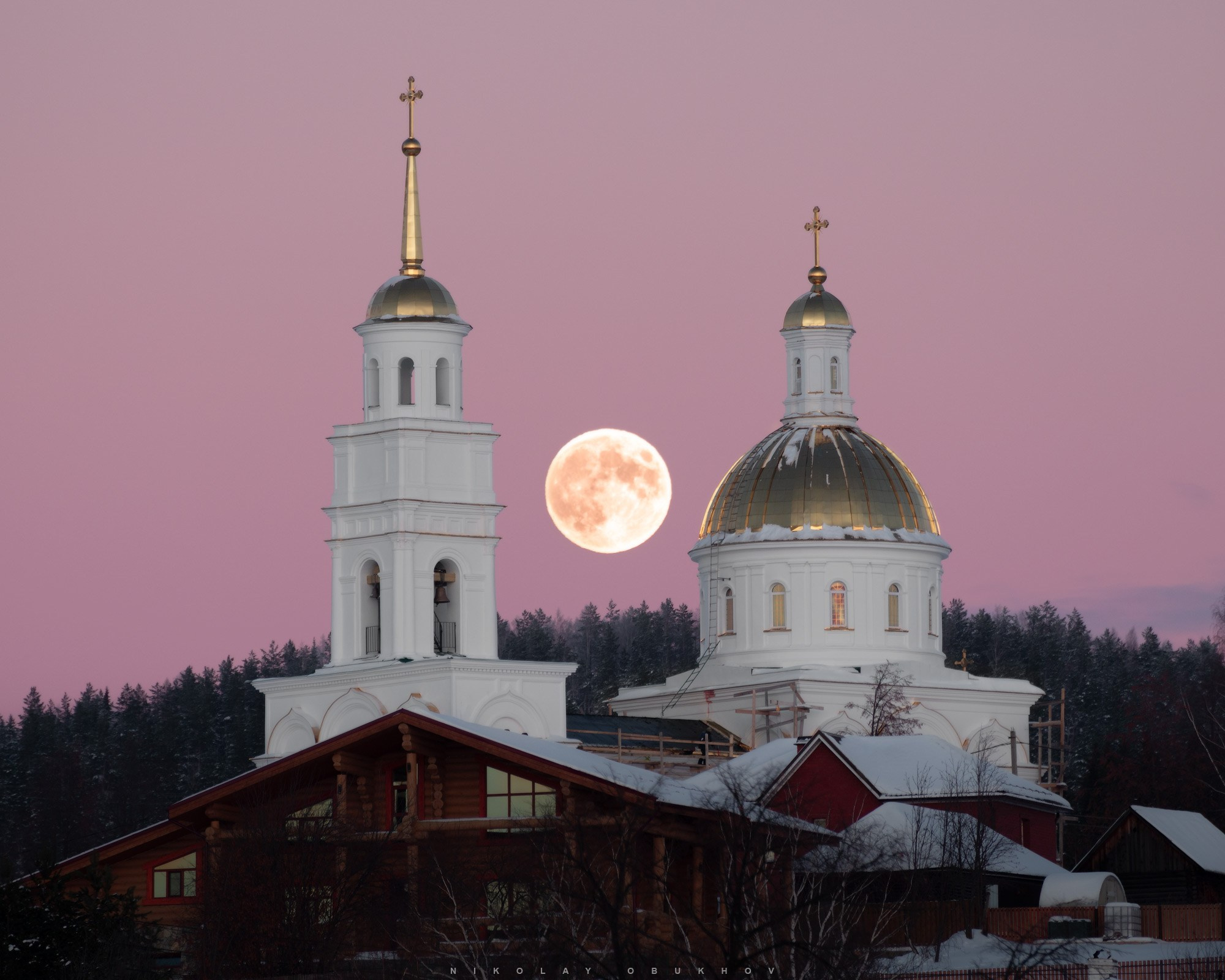 Храм (церковь) на фоне восходящей полной луны в поселке Черноисточинск
