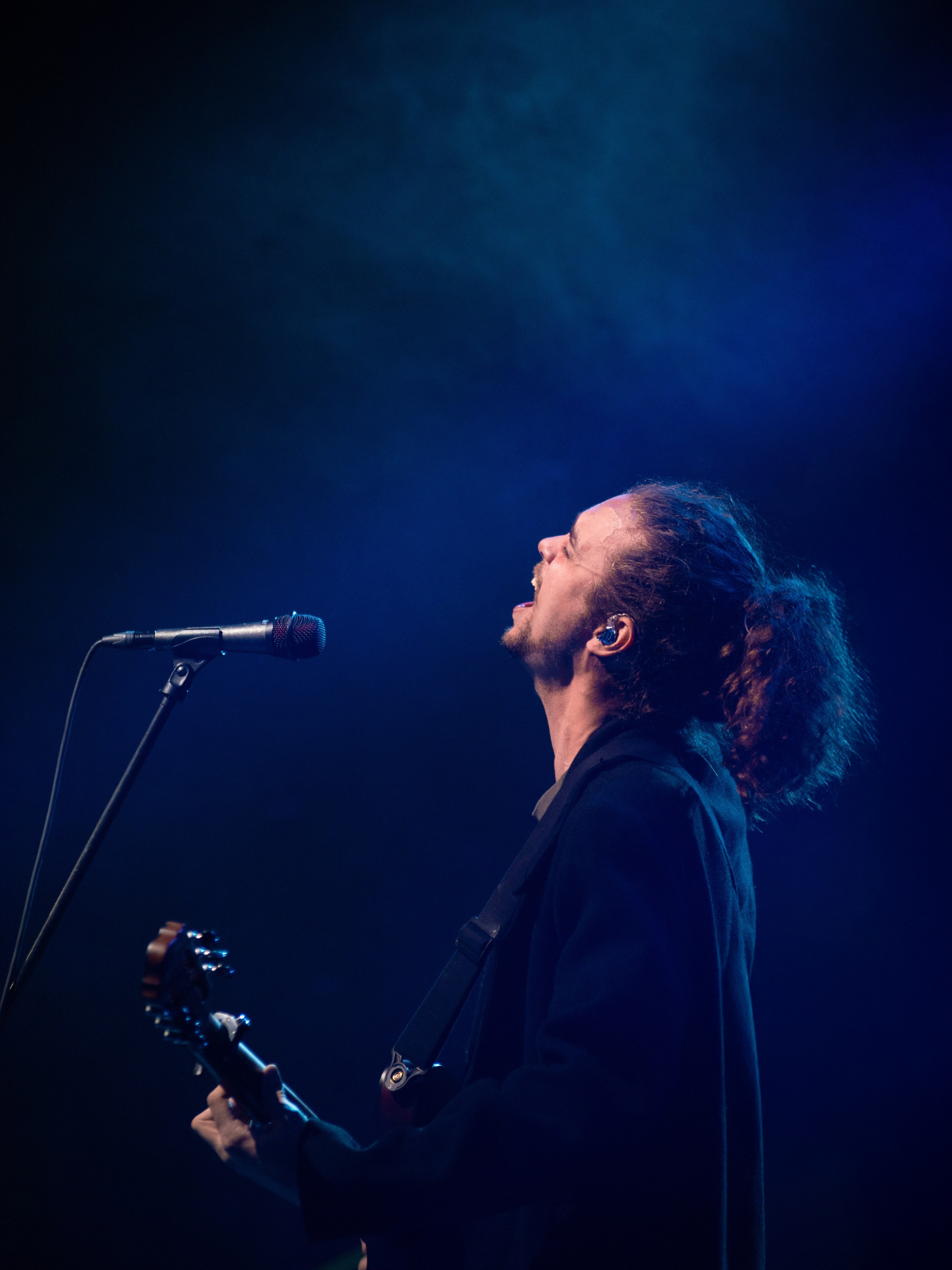 Вокалист группы «Лампабикт» с поднятой головой в синем сценическом дыме