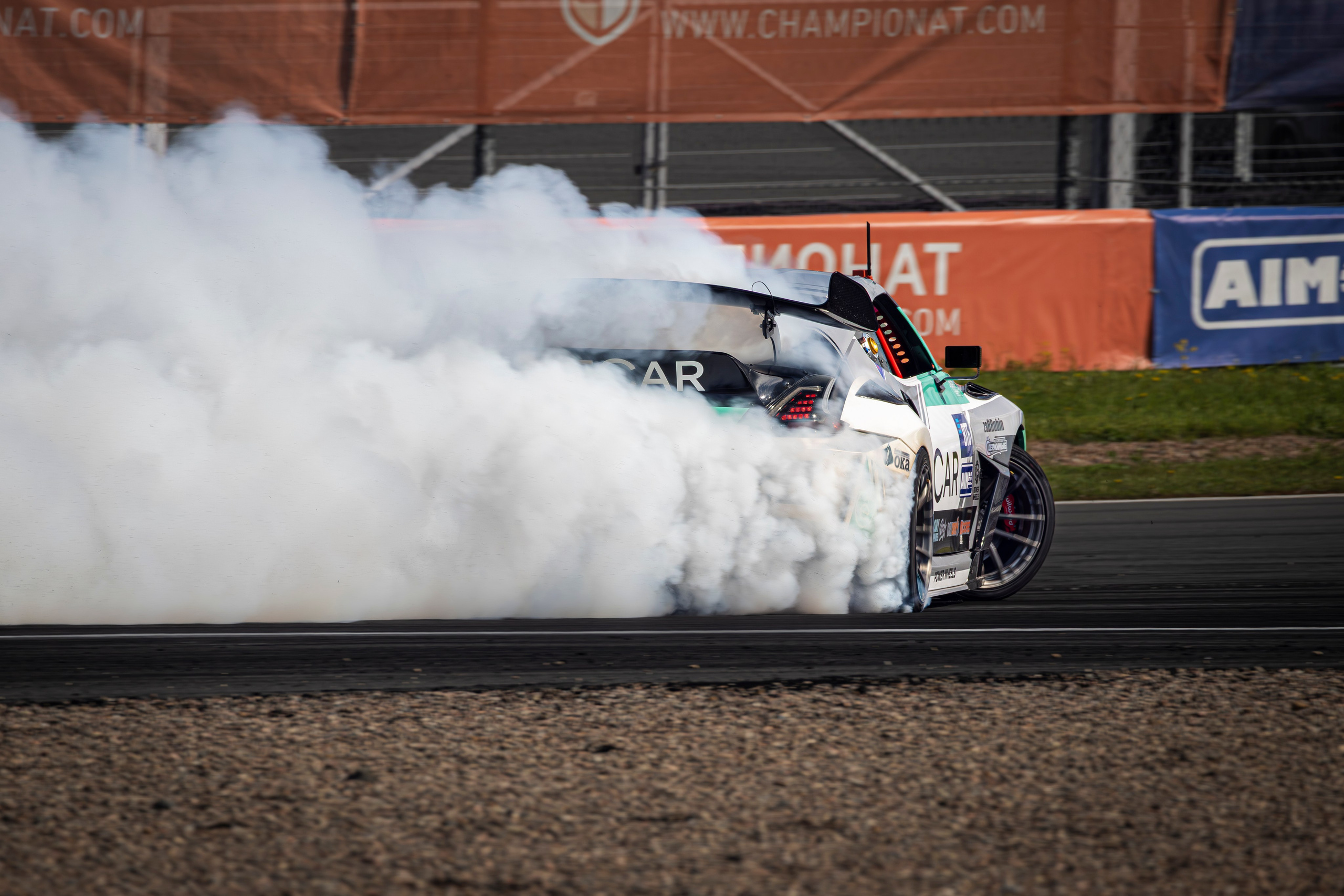 Автомобиль в заносе: клубы дыма, визг шин, динамика движения.