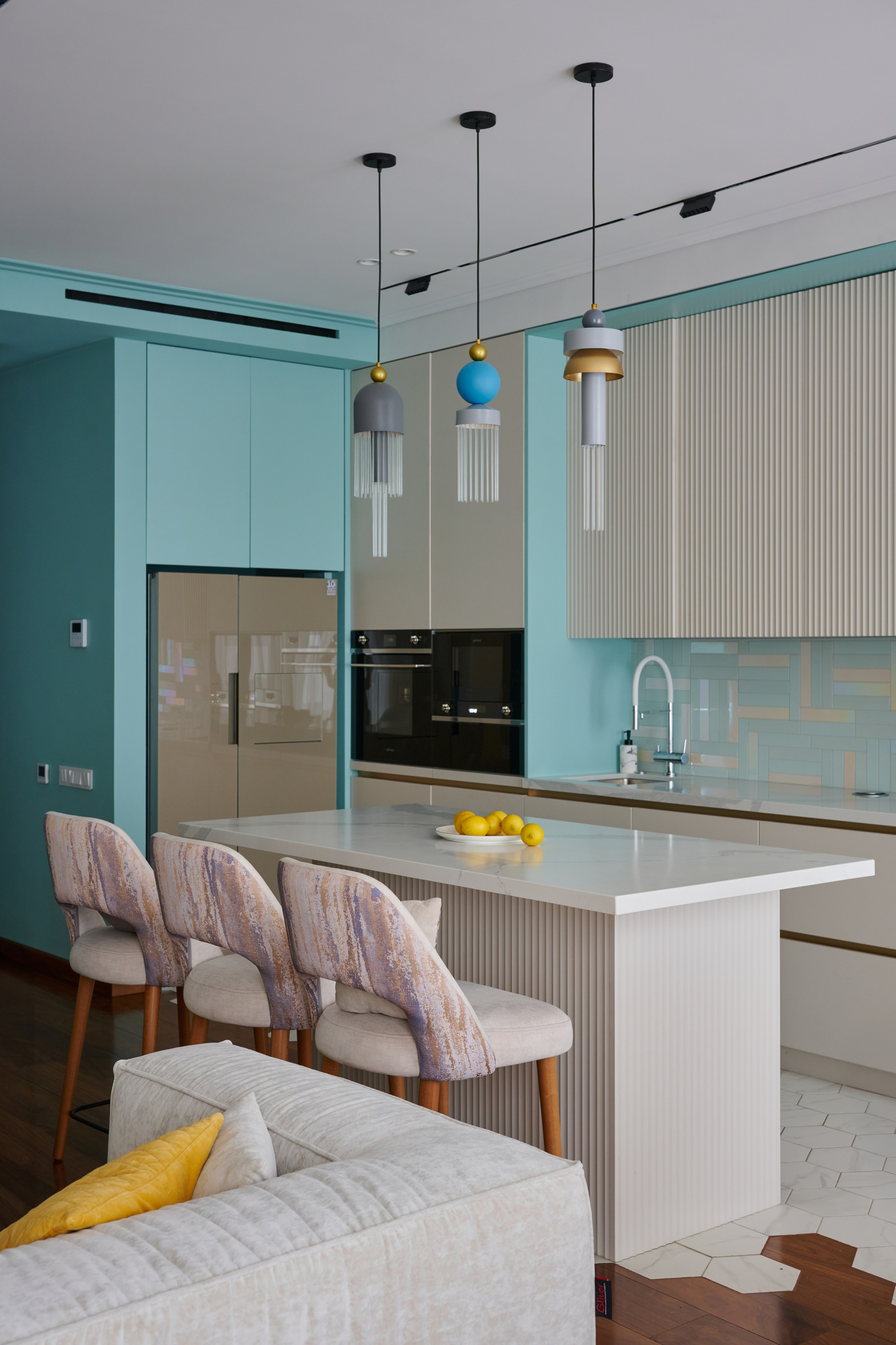 Бирюзовая кухня с островом, подвесные светильники и табуреты