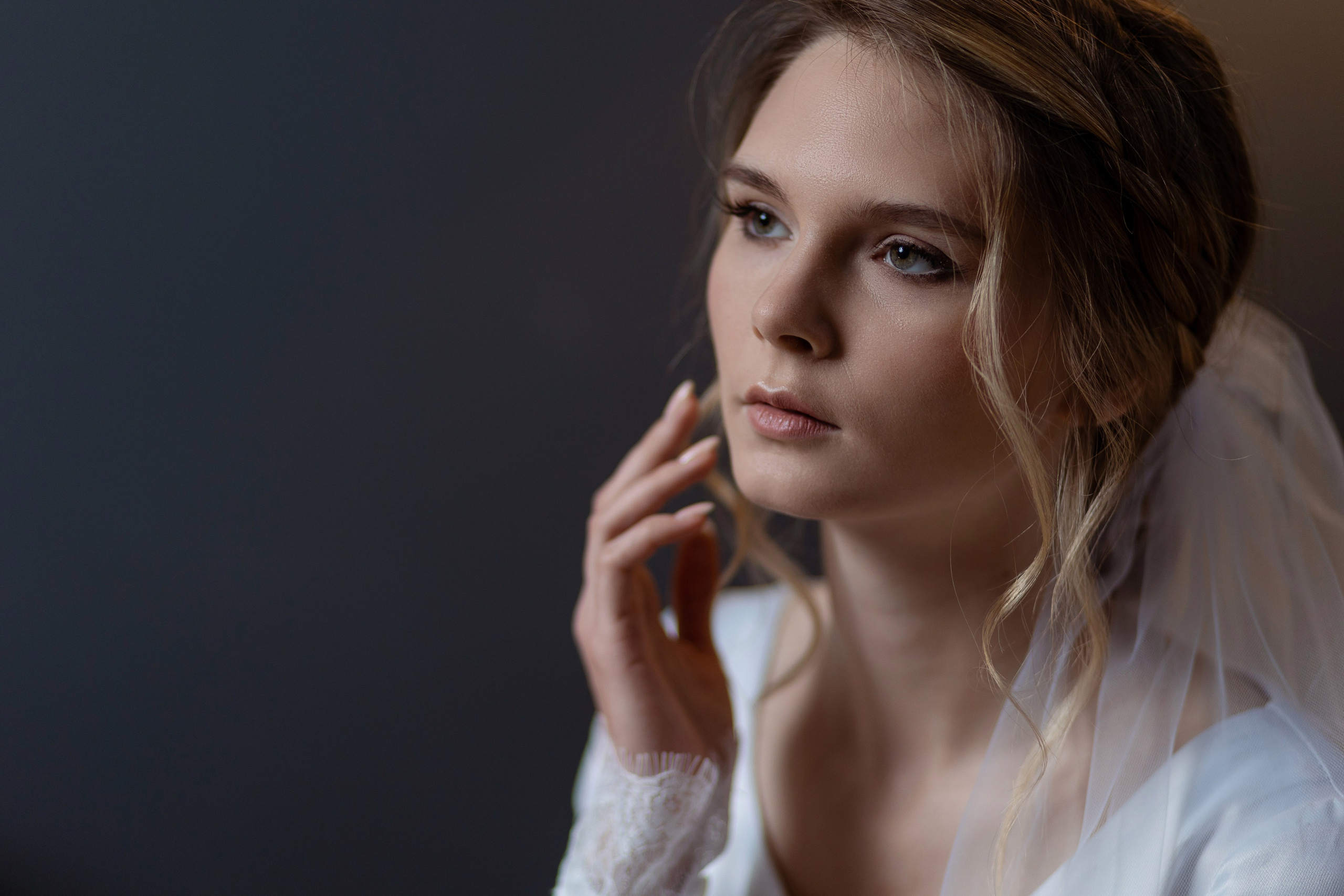 Невеста поднесла руку к лицу, локоны спускаются от виска