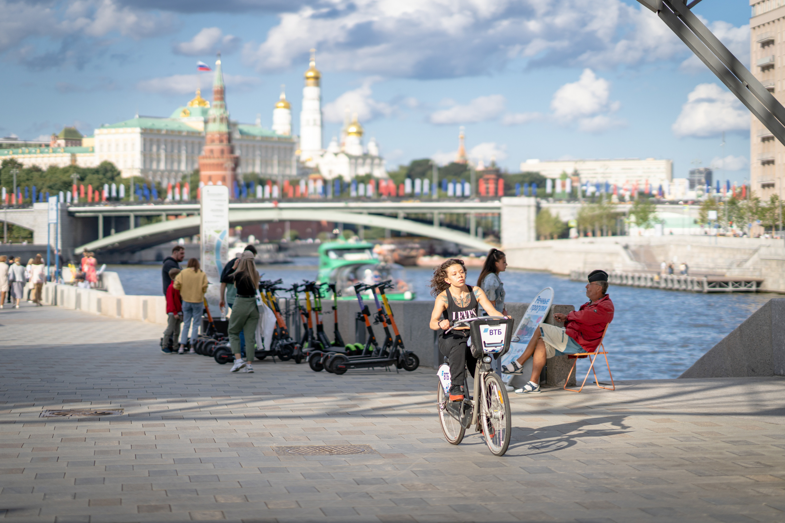 Девушка на прокатном велосипеде у Кремля в Москве