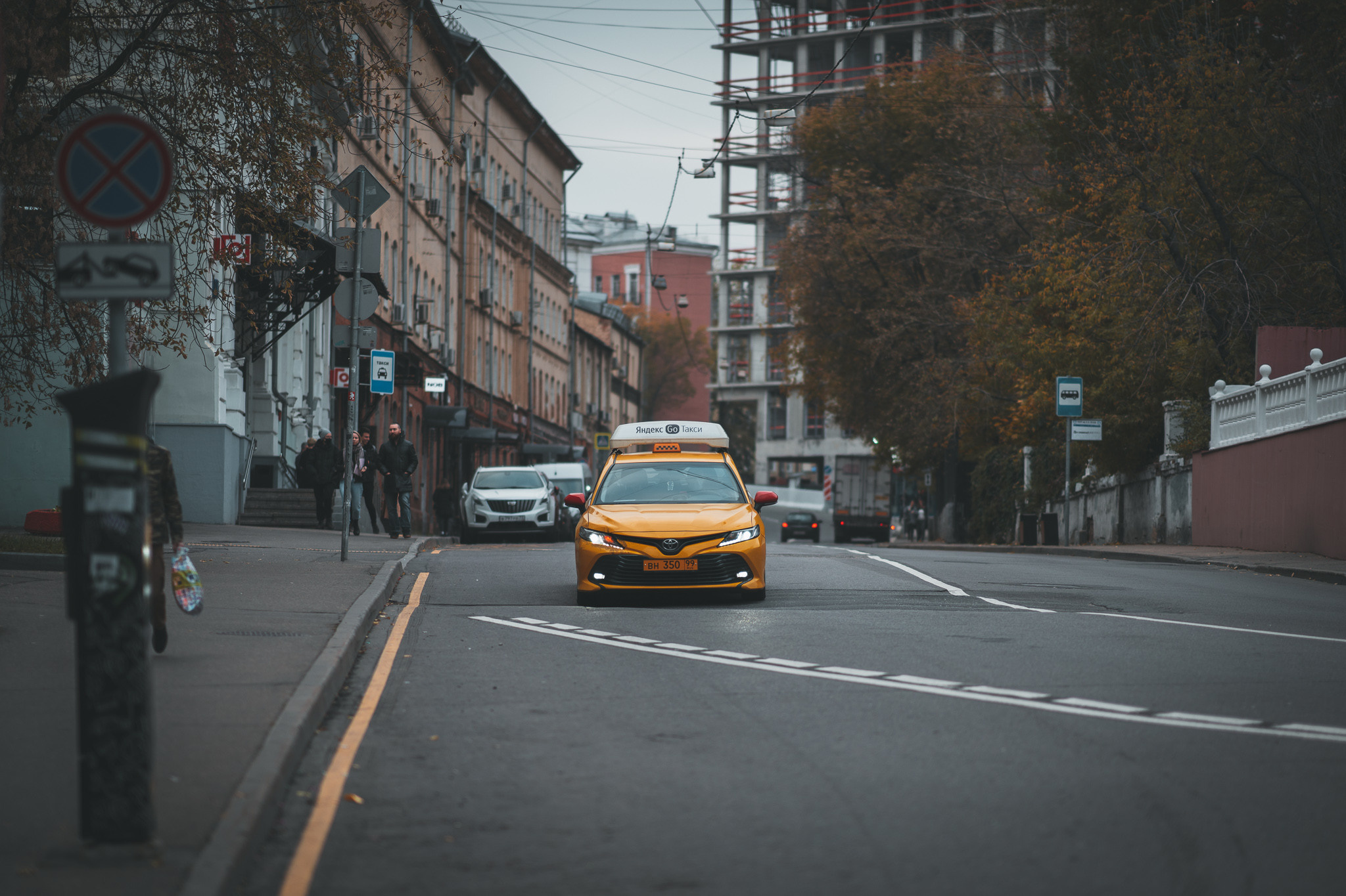 Желтое такси еде по улице Казакова в Москве