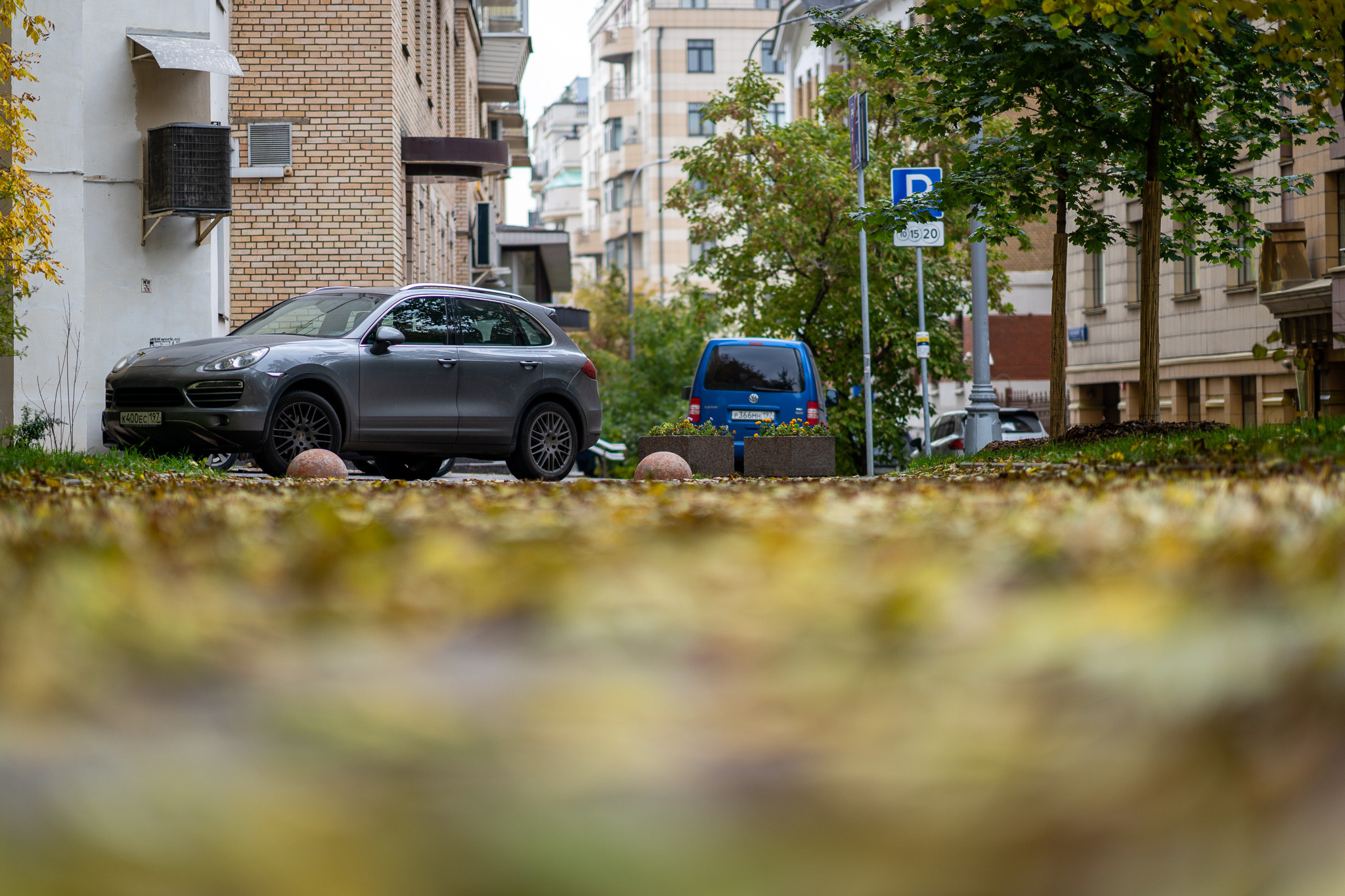 Машина стоит на ковре из желтых осенних листьев