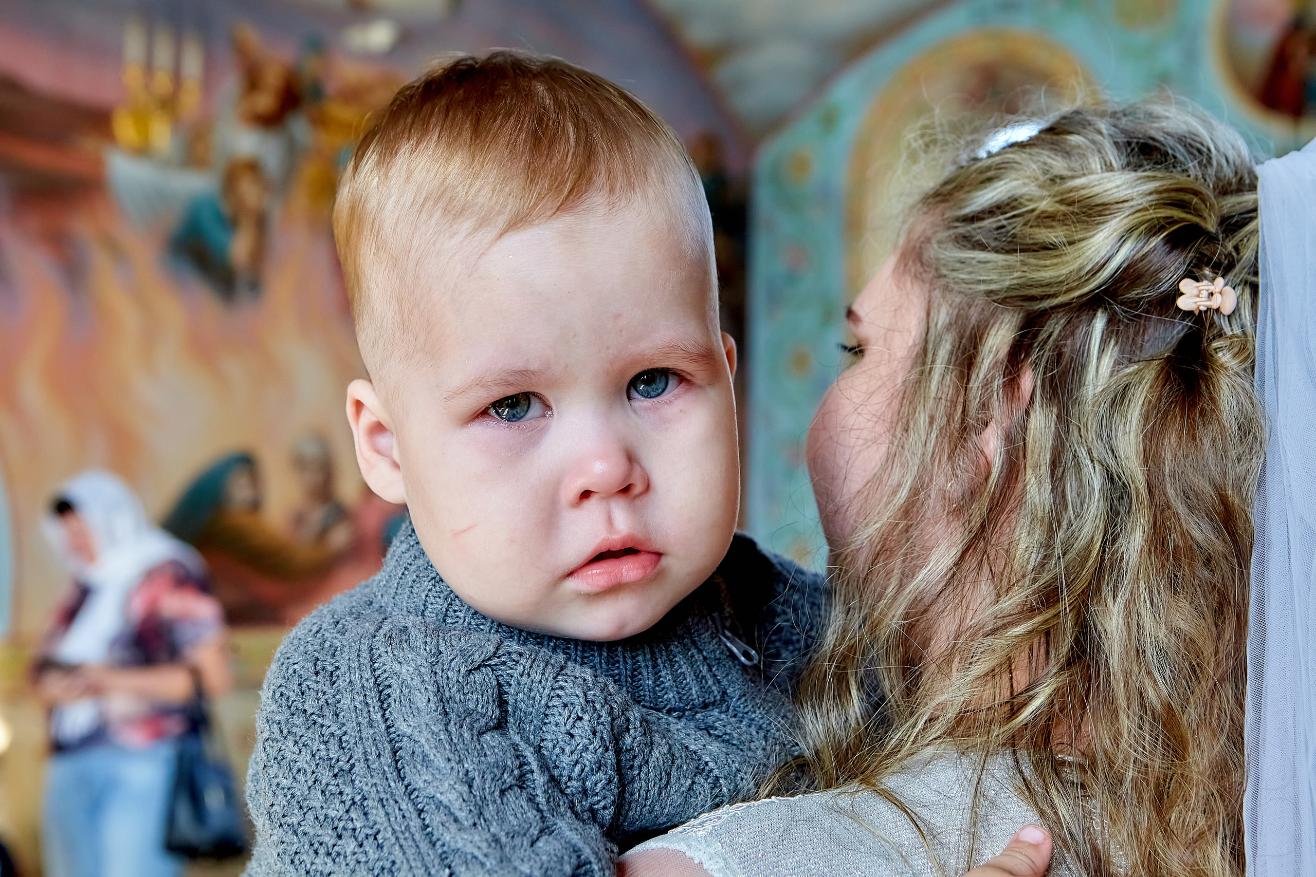 Невеста после венчания с малышом на руках. Мама держит своего малыша малыш смотрит на фотографа